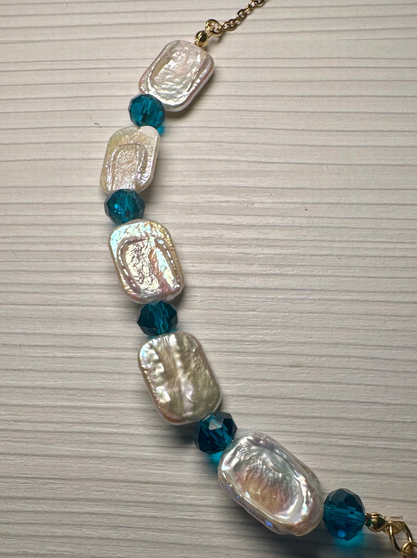 Mermaid’s Relic necklace with nautilus pendant and faceted teal crystal drops.