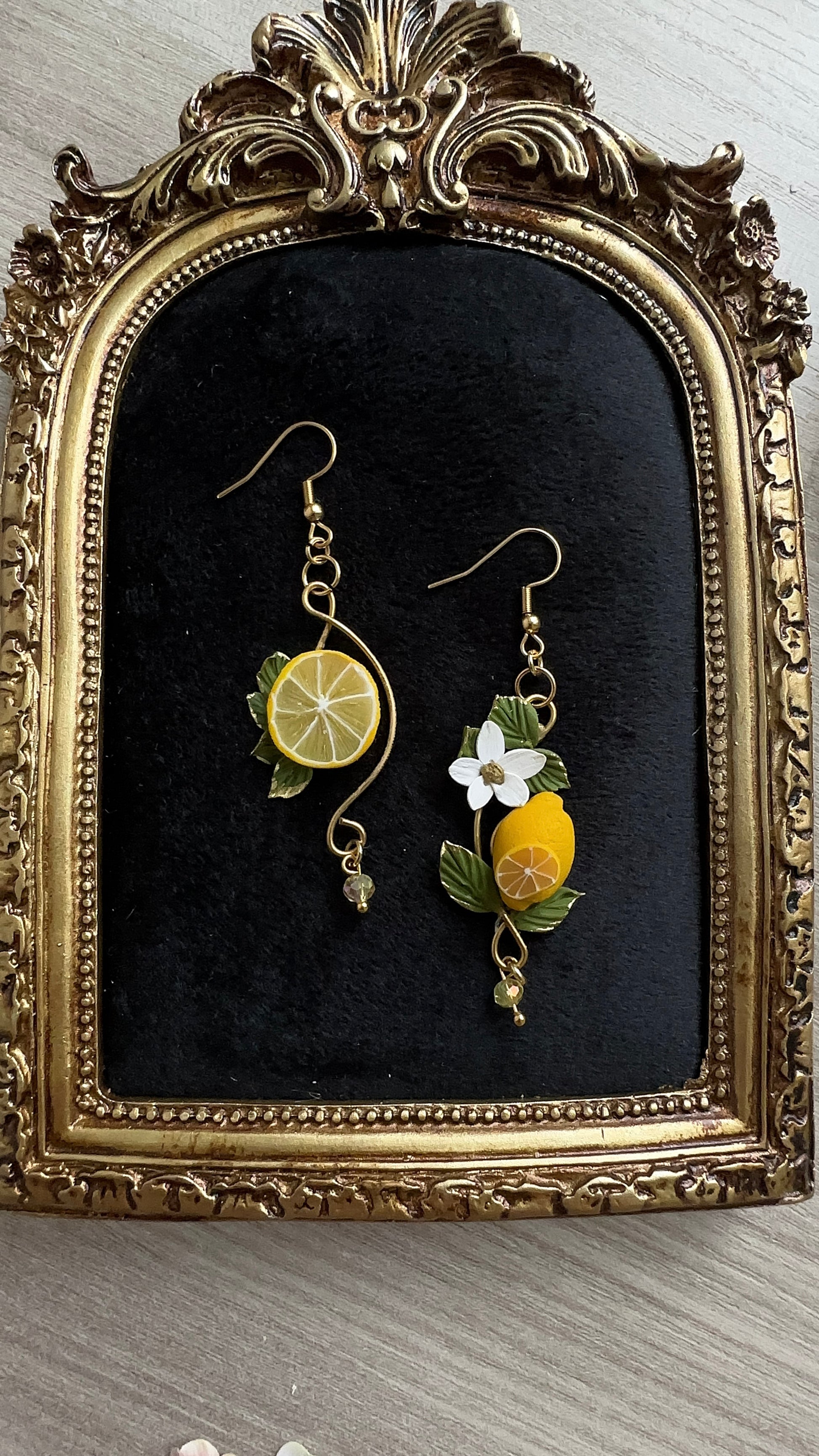 Close-up of asymmetrical lemon earrings handcrafted in polymer clay – Sun-Kissed Lemons by Le Petit Délice. Art Nouveau inspired.