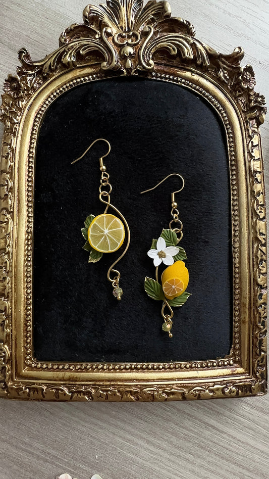 Close-up of asymmetrical lemon earrings handcrafted in polymer clay – Sun-Kissed Lemons by Le Petit Délice. Art Nouveau inspired.