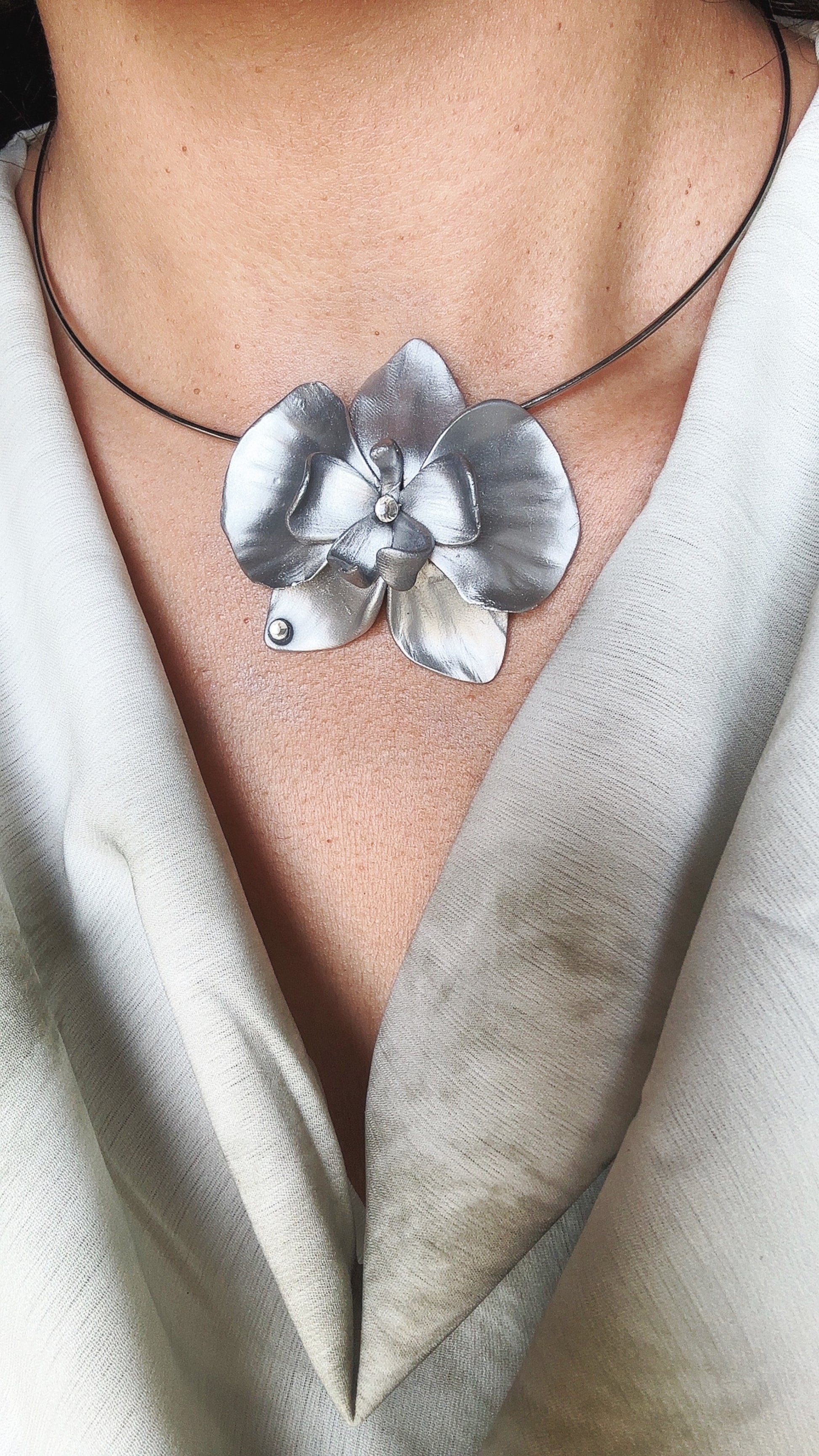 Collana con orchidea argentata – elegante e minimal
Collana con grande orchidea in argento, dal design semplice e raffinato. Un gioiello floreale luminoso e femminile, perfetto per aggiungere un tocco elegante a ogni look.