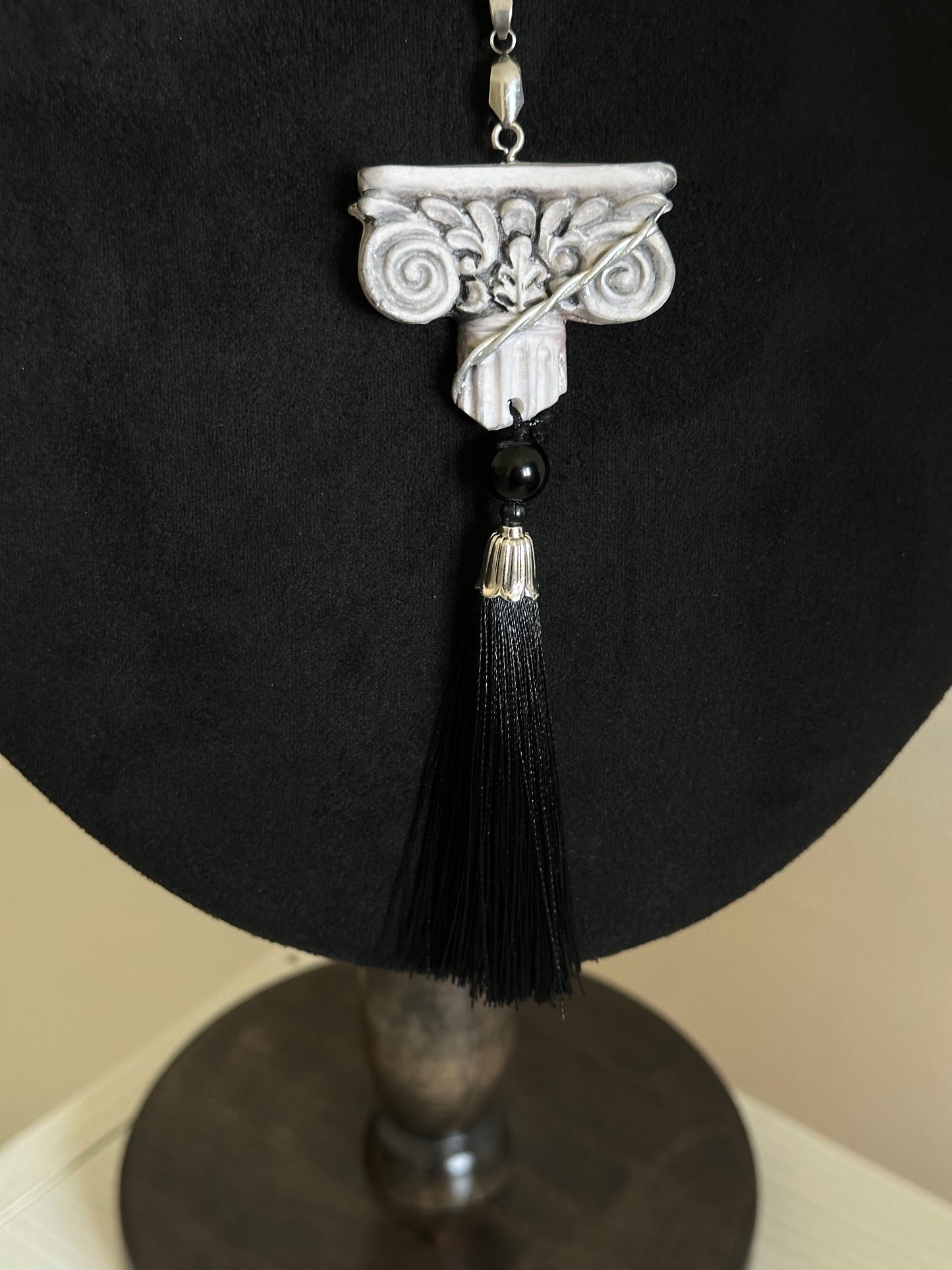 Wearable relic necklace with black thread tassel, dark bead and architectural pendant, unusual statement jewelry for elegant dramatic style.