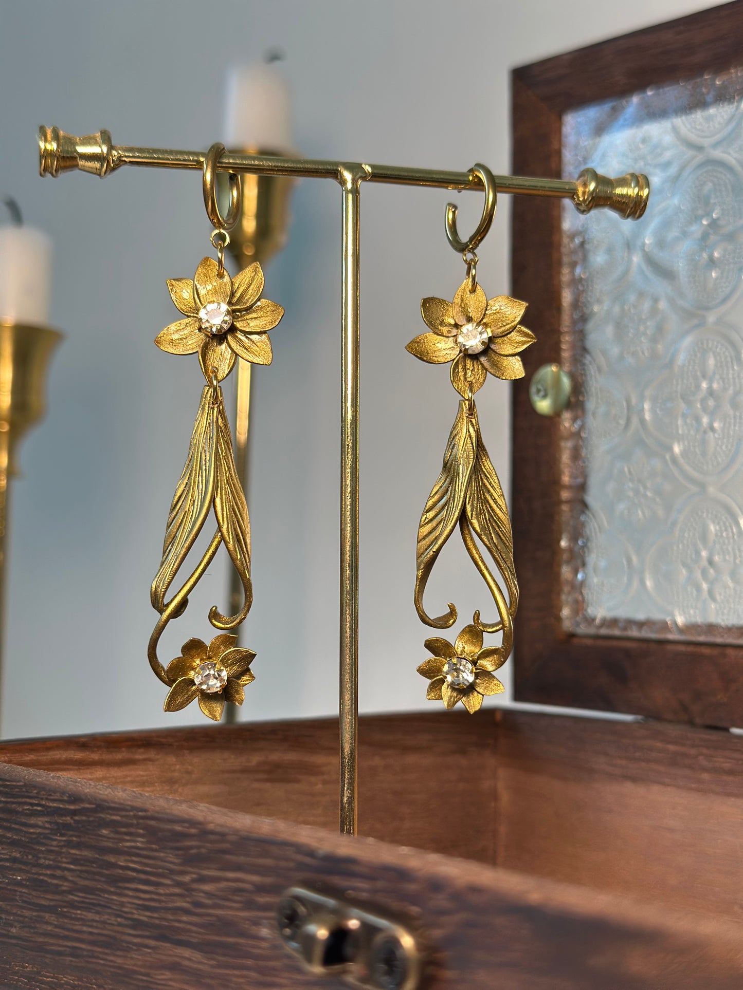 Refined drop earrings with floral motifs and subtle sparkle, photographed as a piece of wearable luxury