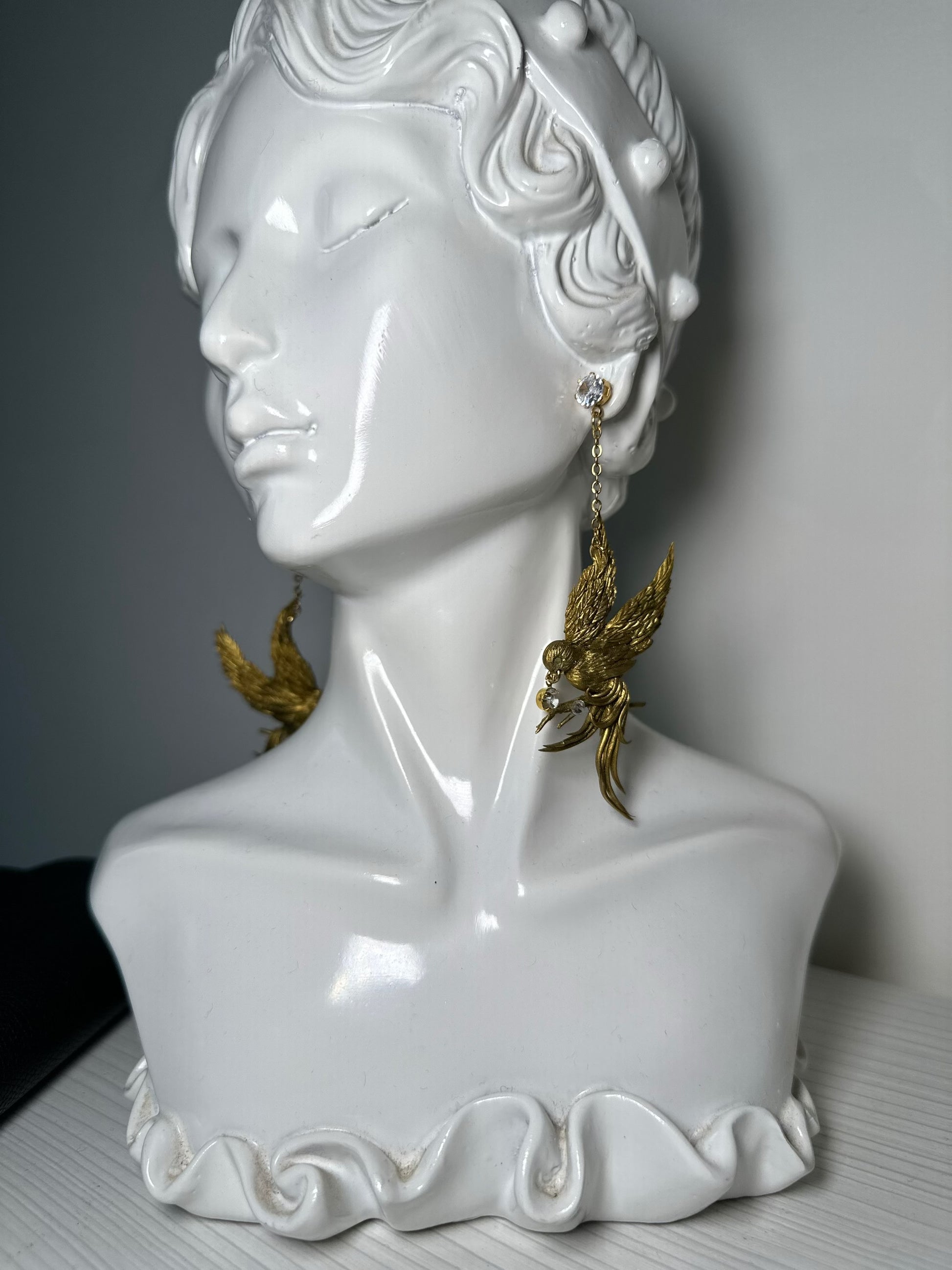 Artisan bird earrings with antique gold finish, modeled by hand and designed for bold, elegant looks.