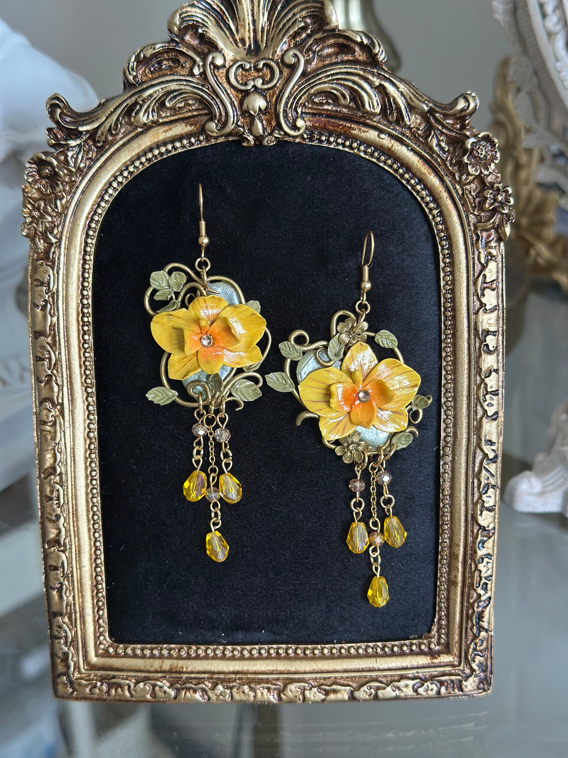 “Handmade yellow orchid earring in polymer clay with Art Nouveau details and stainless steel chains – part of Petali d’Estate summer collection.
Orecchino artigianale con orchidea gialla in pasta polimerica, dettagli Art Nouveau e catene in acciaio – collezione estiva Petali d’Estate