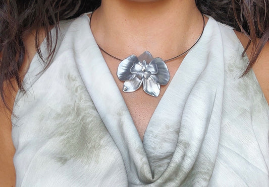 Collana con orchidea argentata – elegante e minimal
Collana con grande orchidea in argento, dal design semplice e raffinato. Un gioiello floreale luminoso e femminile, perfetto per aggiungere un tocco elegante a ogni look.
