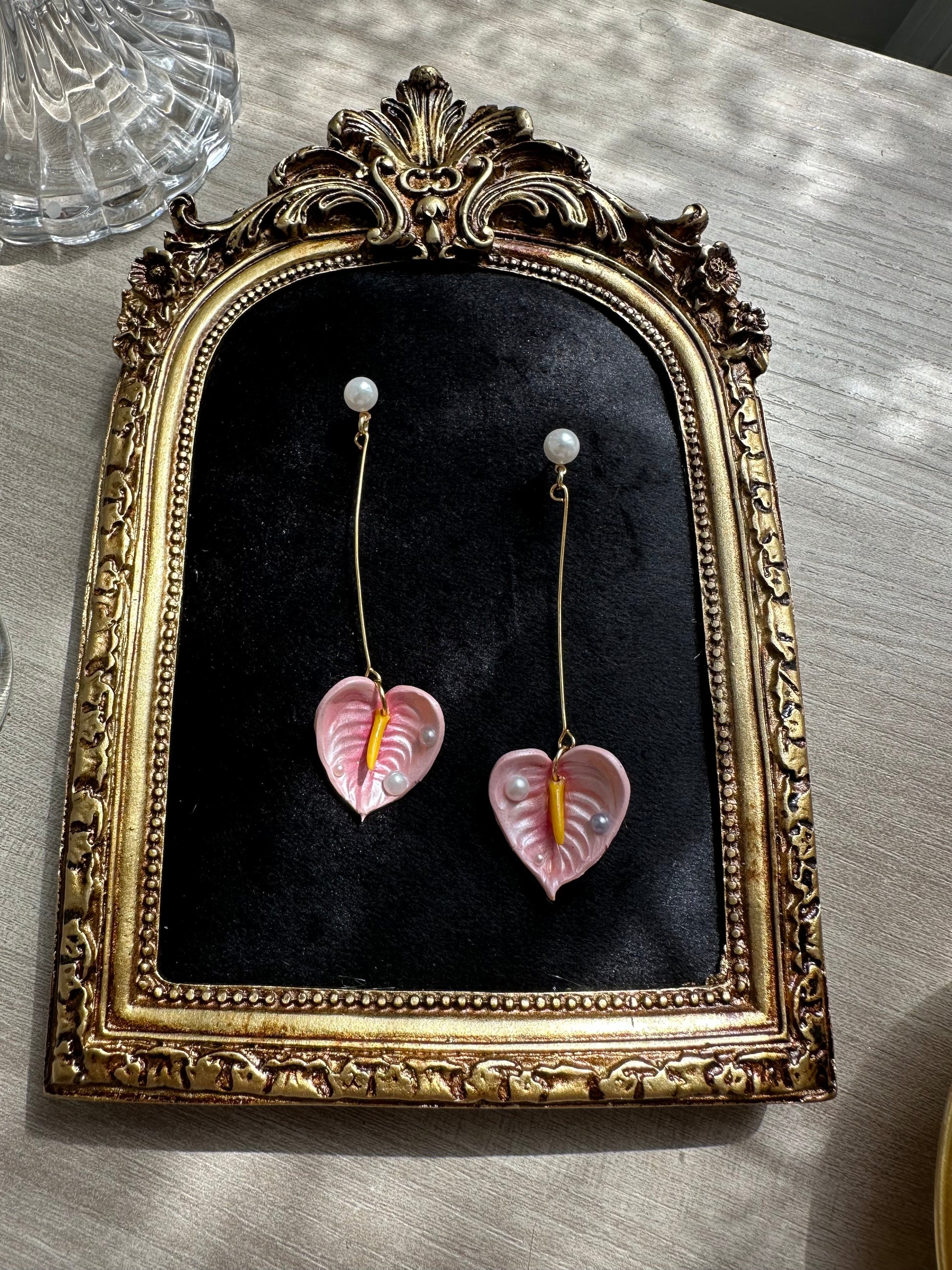 Handmade floral earrings with pink anthurium and pearl drops, long gold structure in stainless steel – inspired by tropical nature.”