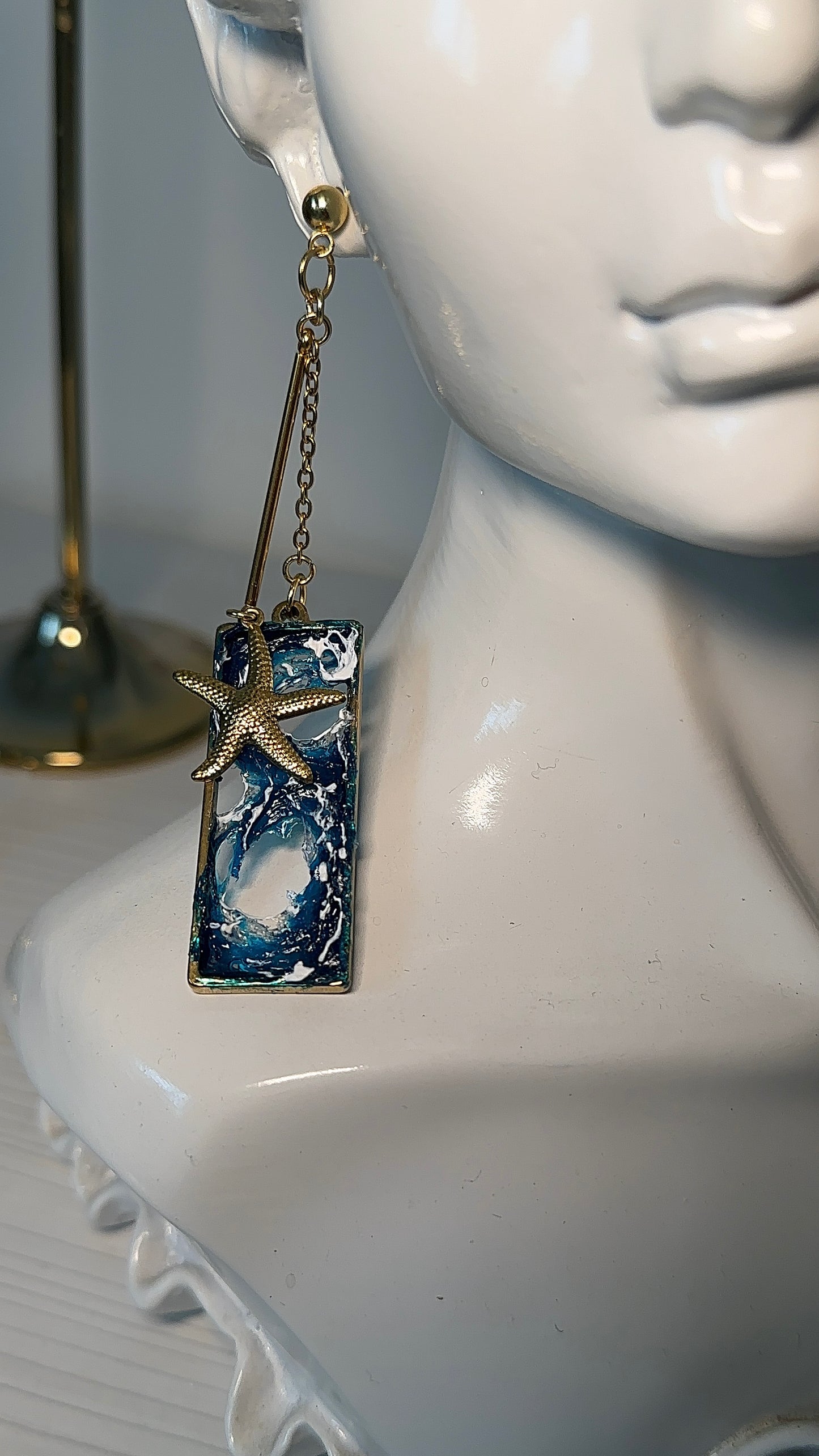 Unique sea-inspired earrings framed in vintage gold and displayed on black velvet