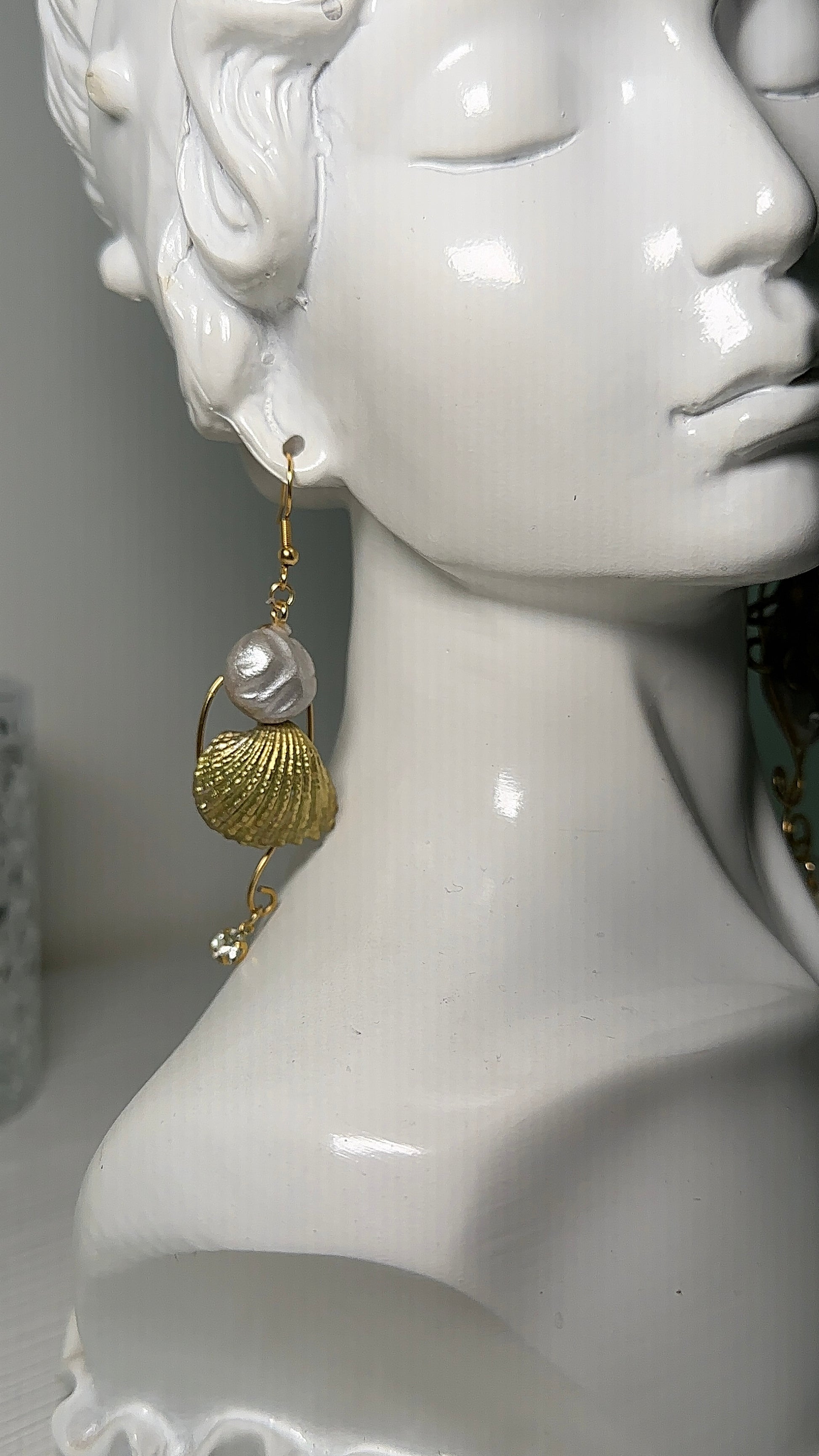 Orecchini marini vistosi con polpo e conchiglia metallici, realizzati a mano in pasta polimerica e decorati con perle d’acqua dolce.