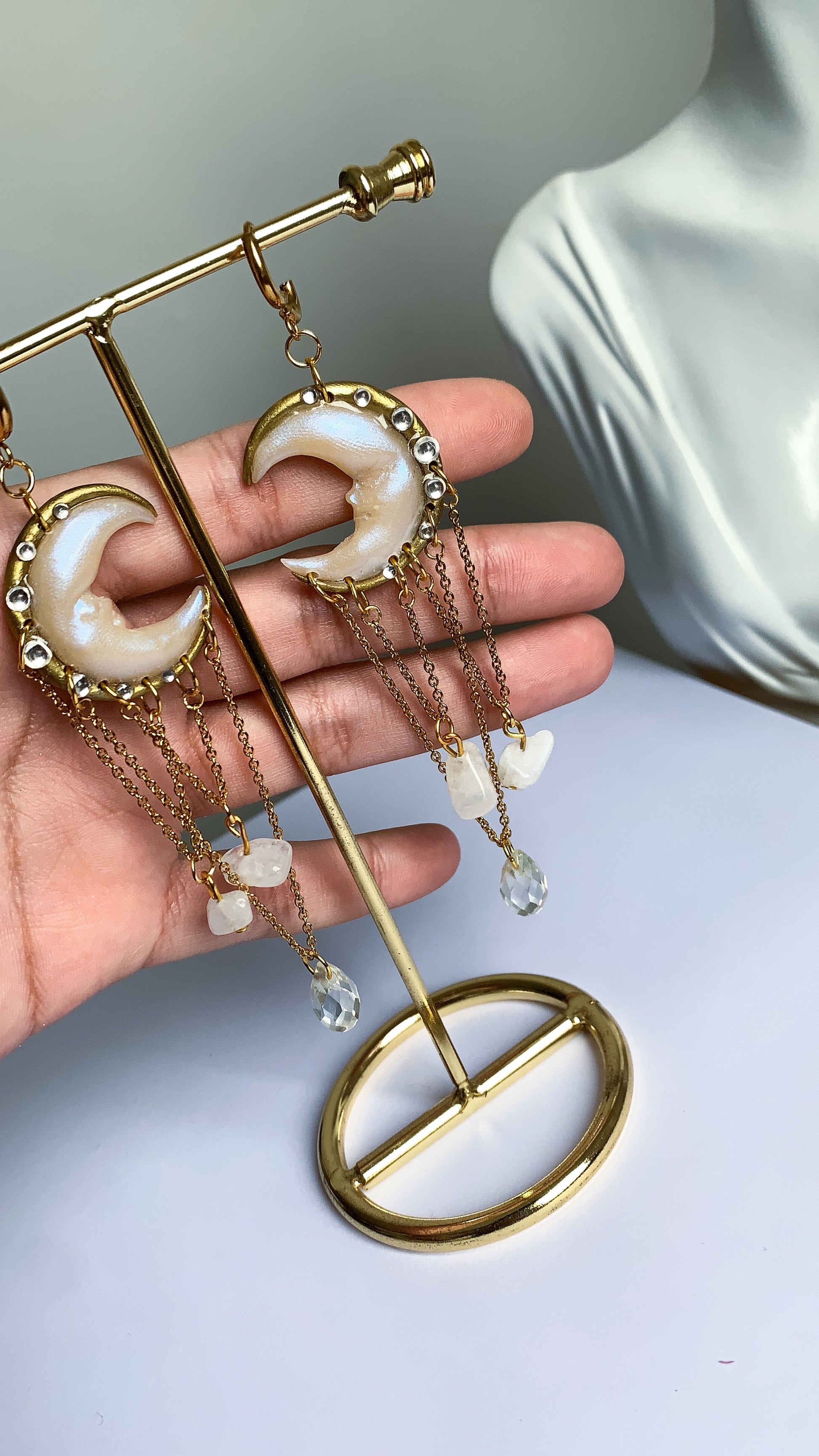 Orecchini lunghi con lune scolpite a mano e gocce trasparenti, perfetti per look raffinati e femminili.