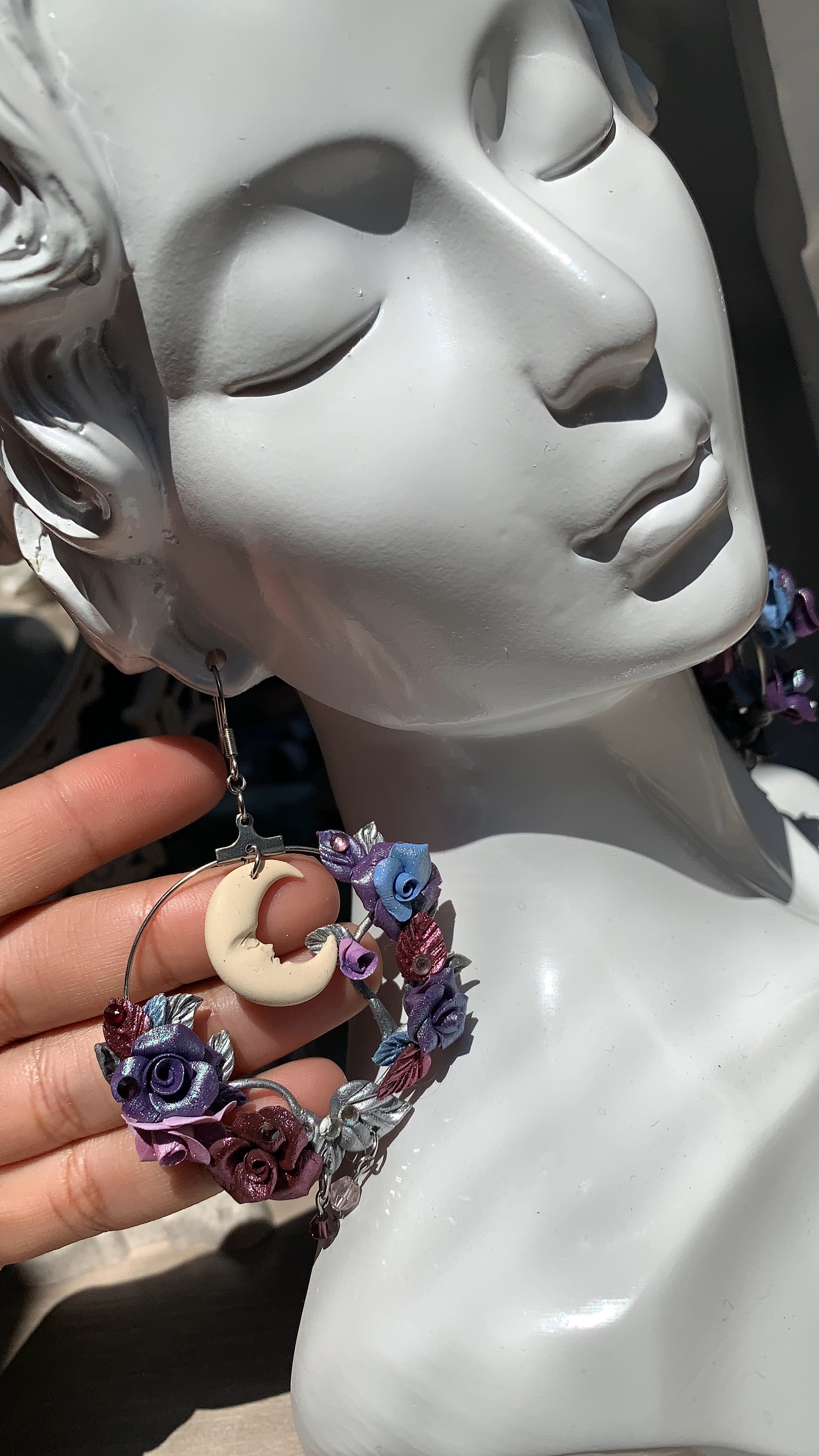 Whimsical statement earrings featuring a handmade owl, moon, and floral arrangement in cool twilight tones