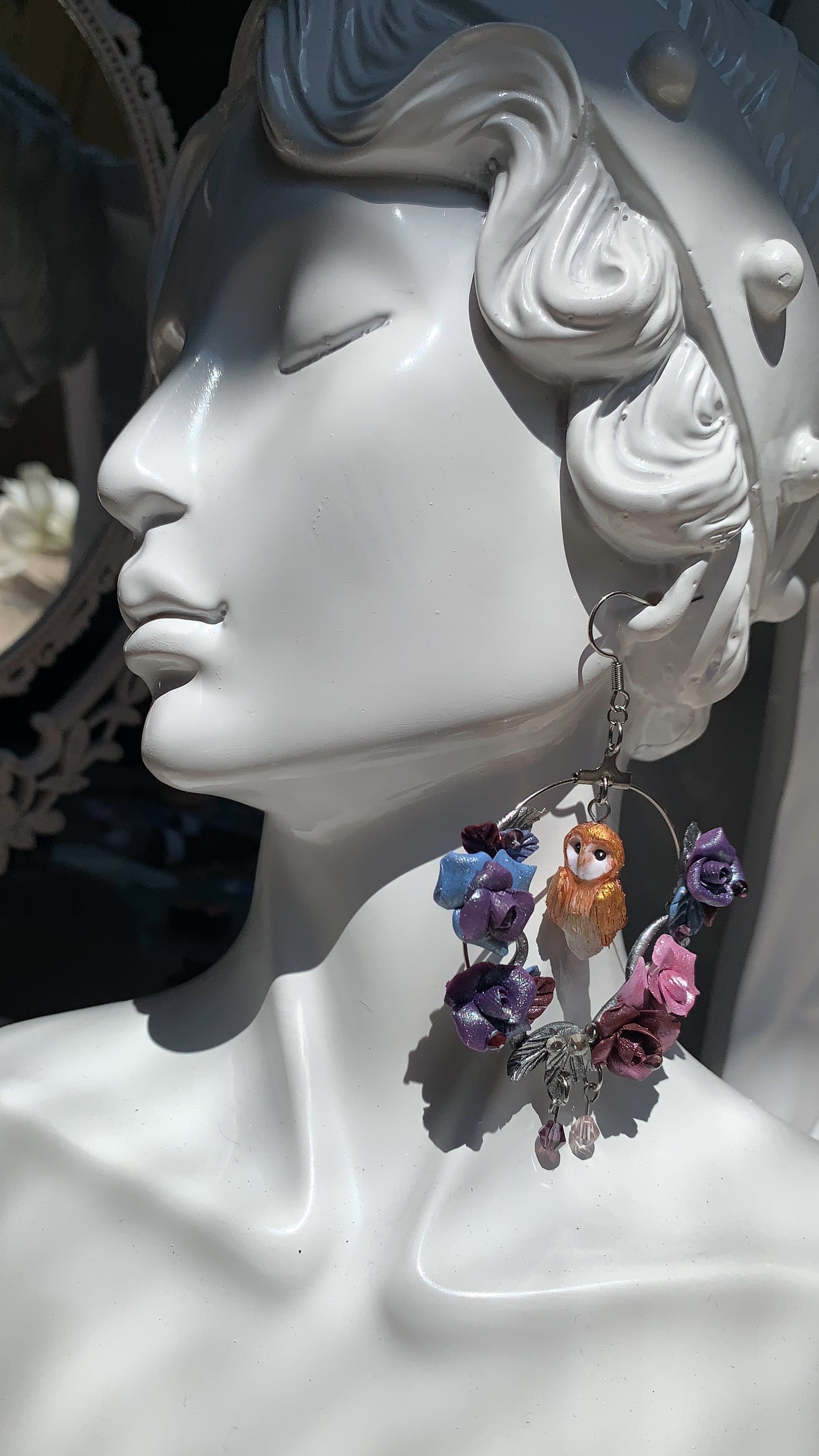 Orecchini a cerchio con gufo in miniatura modellato a mano, circondato da rose viola e luna crescente.