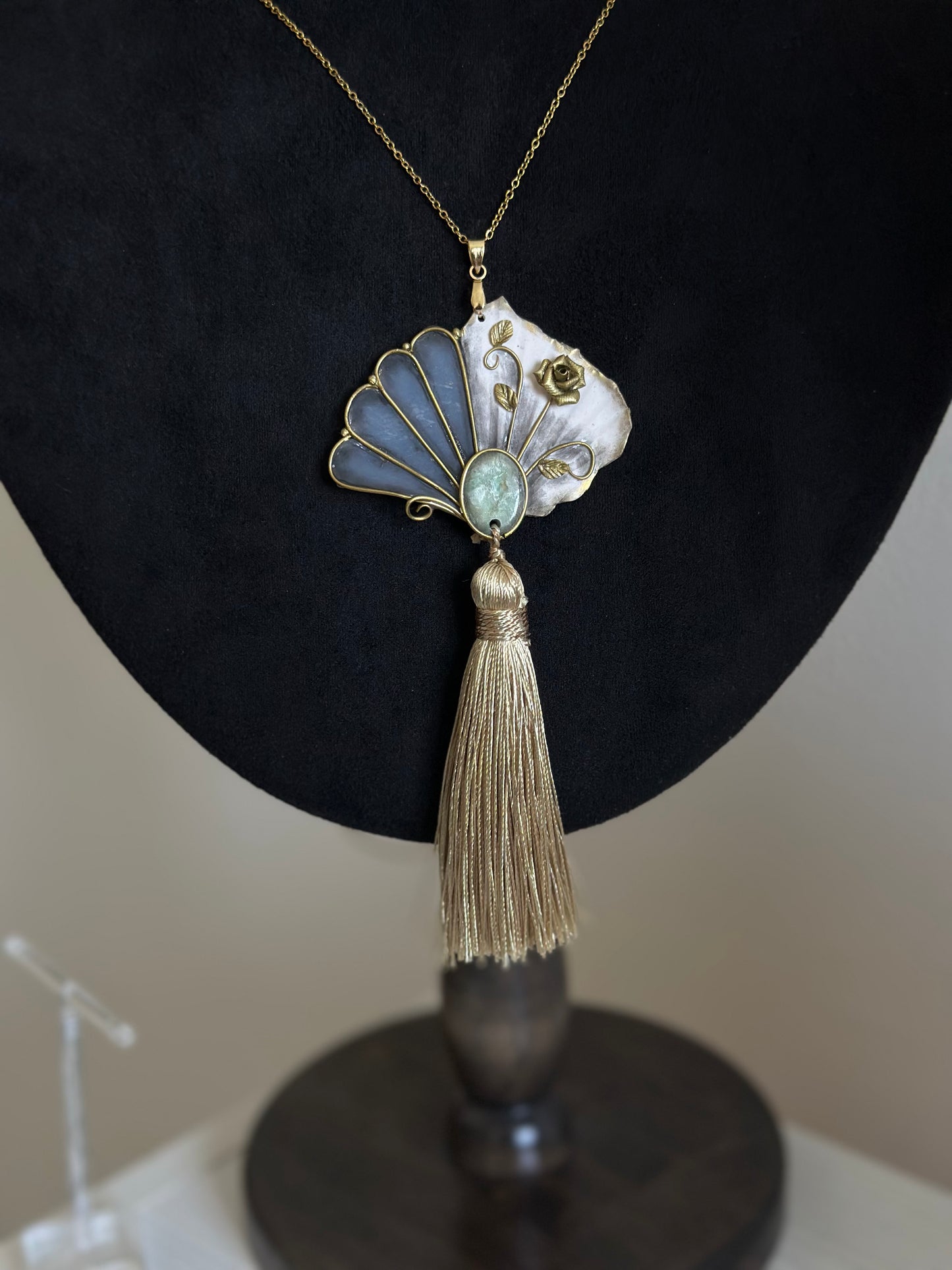     Vintage-inspired wearable relic necklace with fan-shaped pendant, green detail and soft golden tassel, unusual statement necklace for elegant outfits.