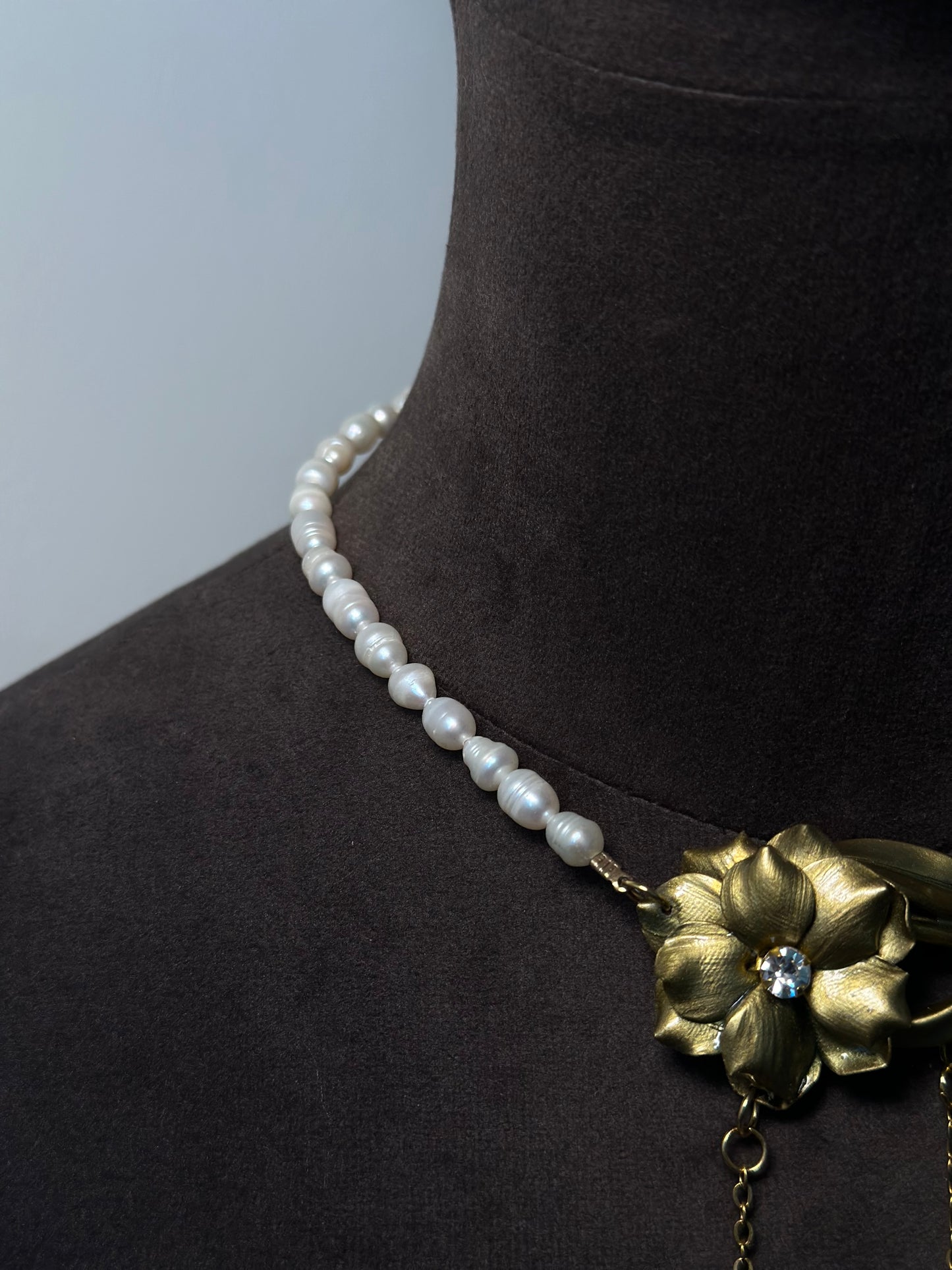 Elegant pearl and gold flower necklace with delicate hanging charms, artistic botanical statement piece for refined style