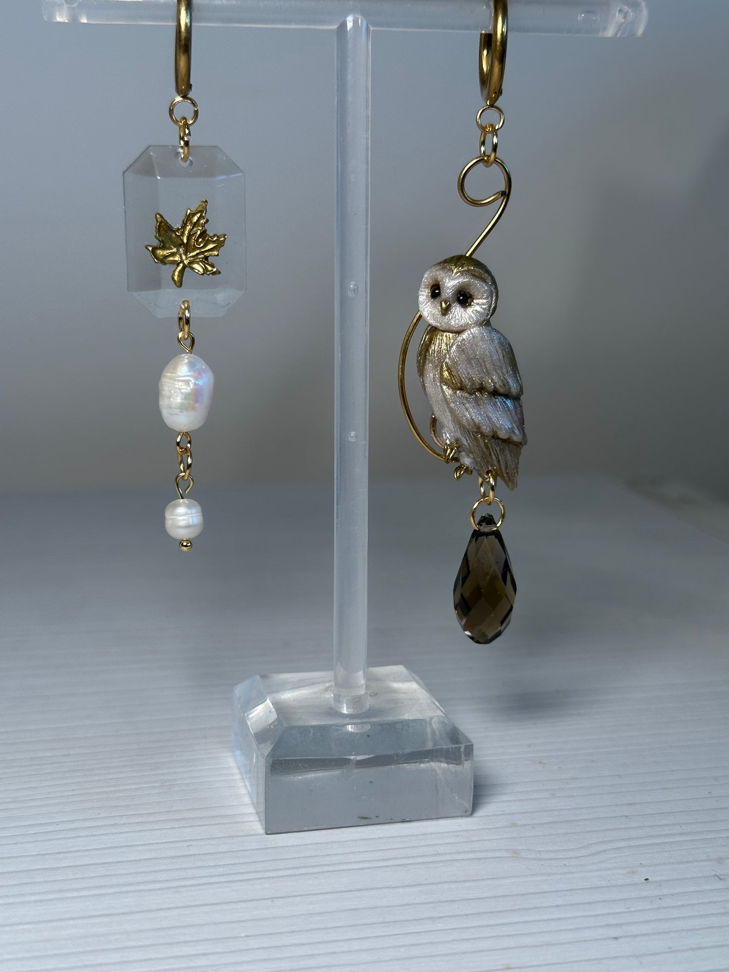 Elegant autumn earrings in resin and polymer clay, showcasing a golden owl and maple leaf design for quiet luxury lovers.