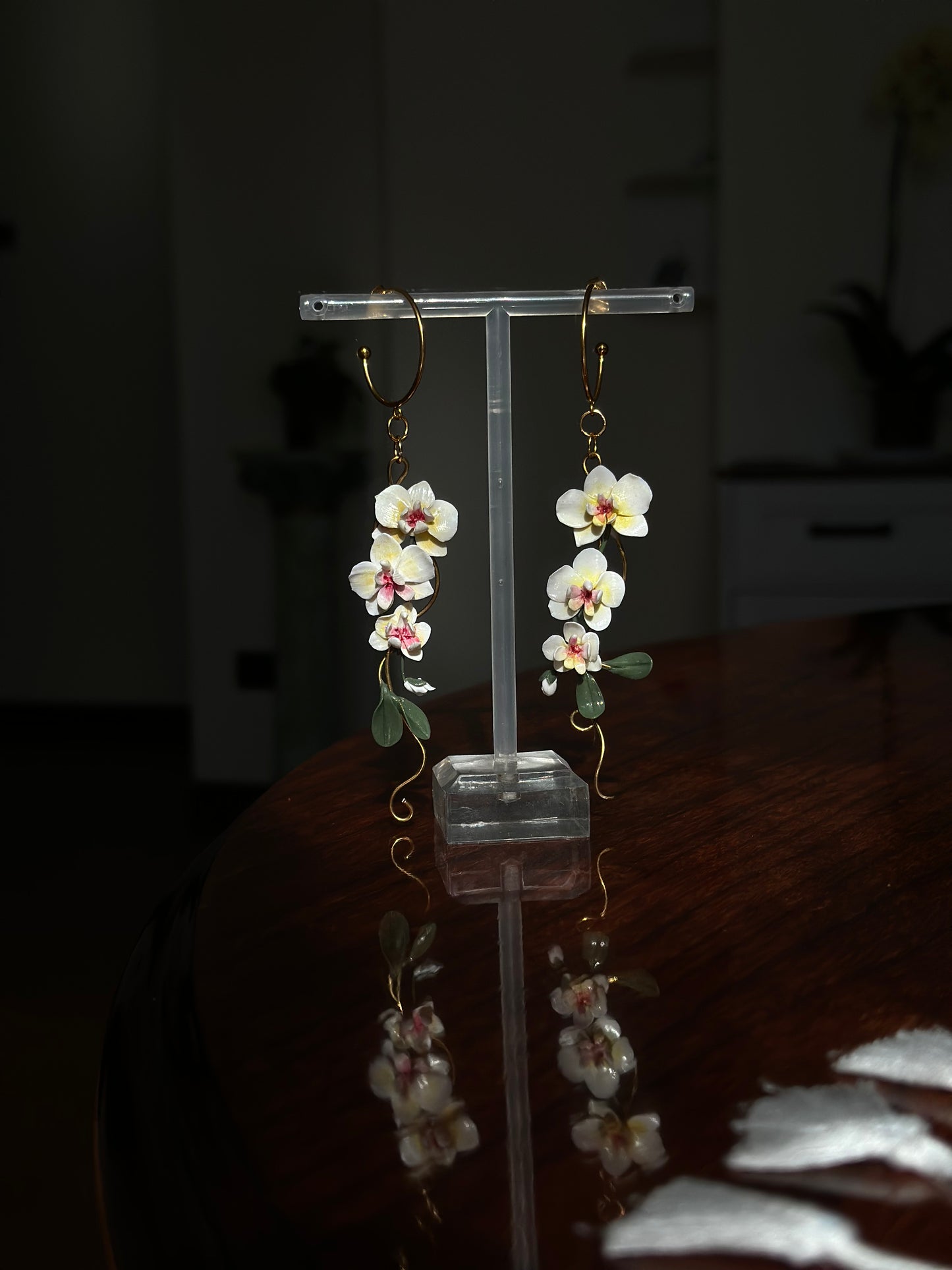 Long floral statement earrings featuring hand-sculpted white orchid flowers in polymer clay, designed for elegant summer outfits.