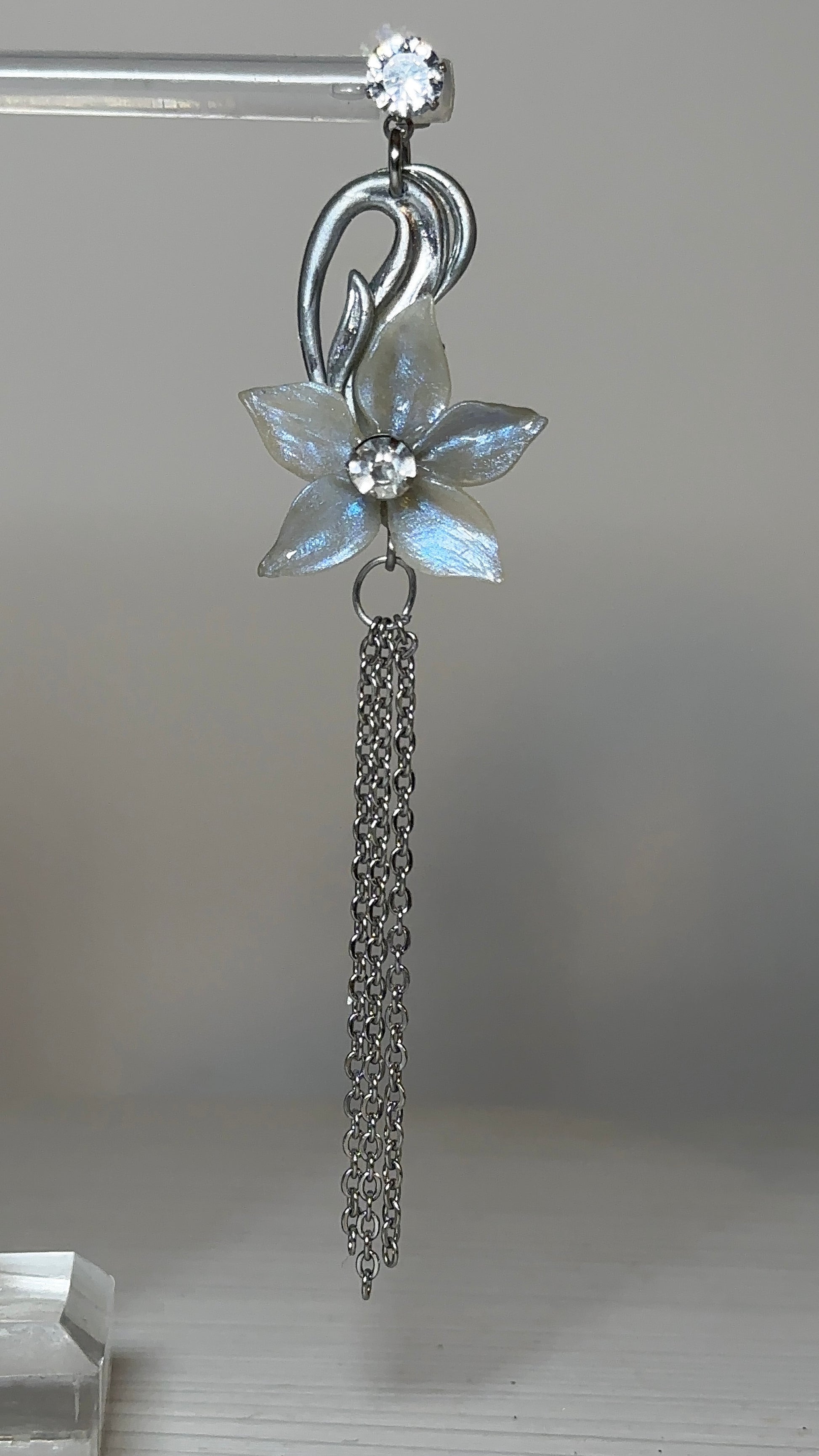 Romantic statement earrings with floral motifs, soft luminous petals, and fine silver detailing, captured in a classic, sculptural setting.