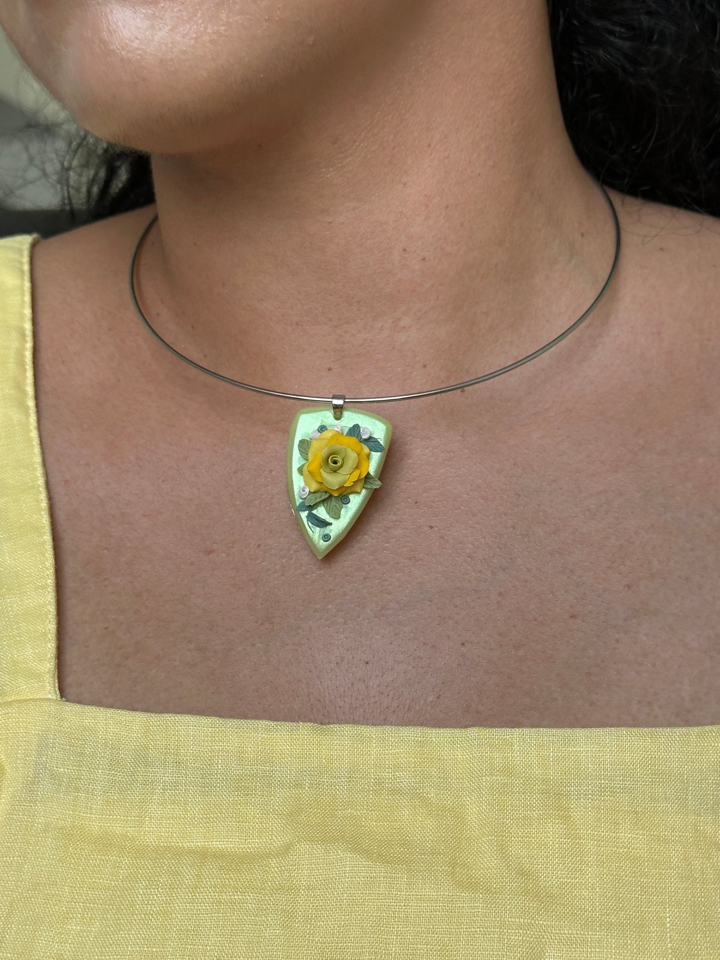     Unique handmade botanical pendant necklace with sculpted yellow rose, green base and delicate leaf details from the Eden Reverie collection.