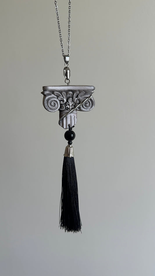     Handmade architectural tassel necklace with sculptural column pendant, black tassel and dark bead for dramatic refined outfits.