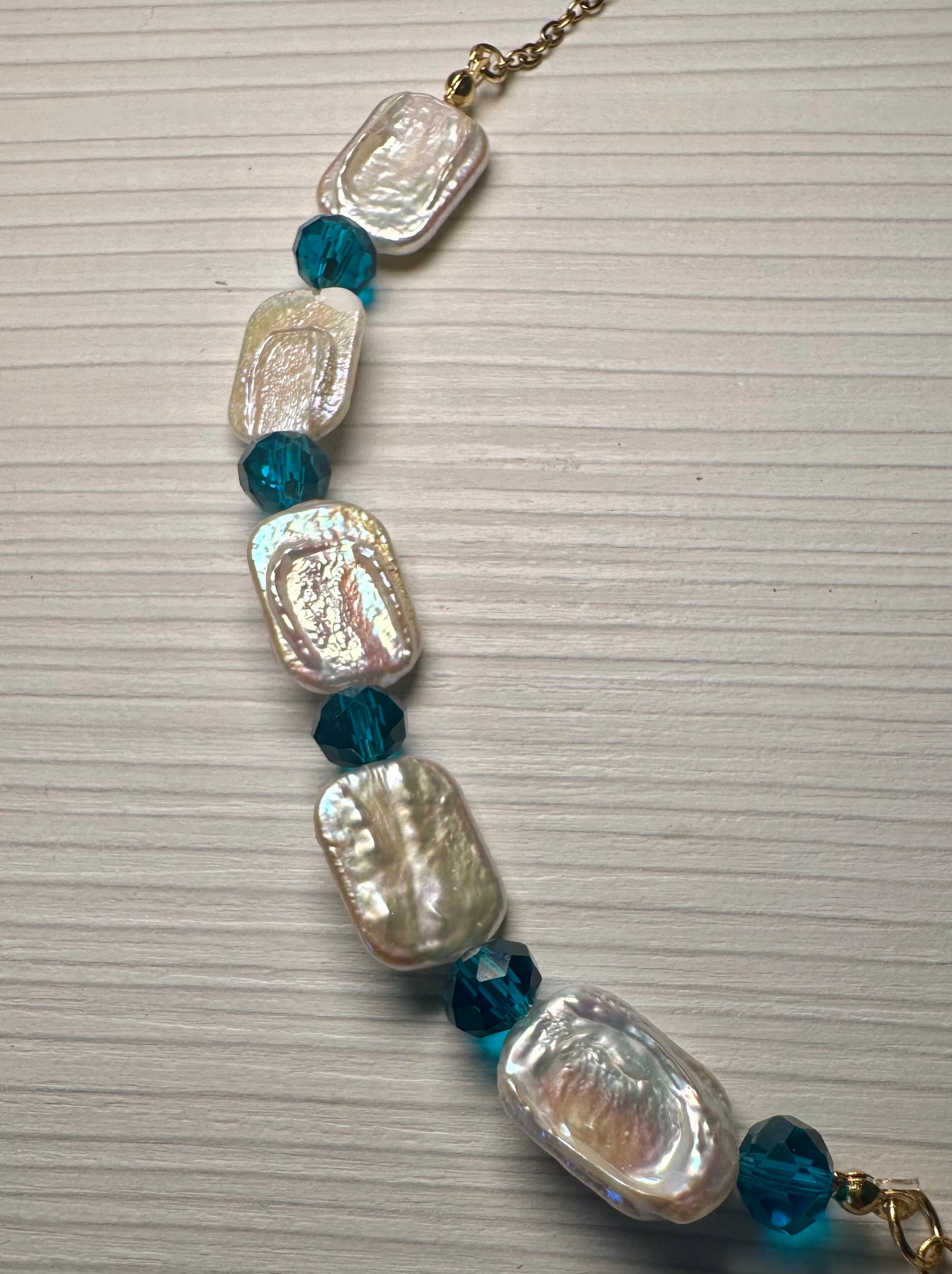 Mermaid’s Relic necklace with nautilus pendant and faceted teal crystal drops.