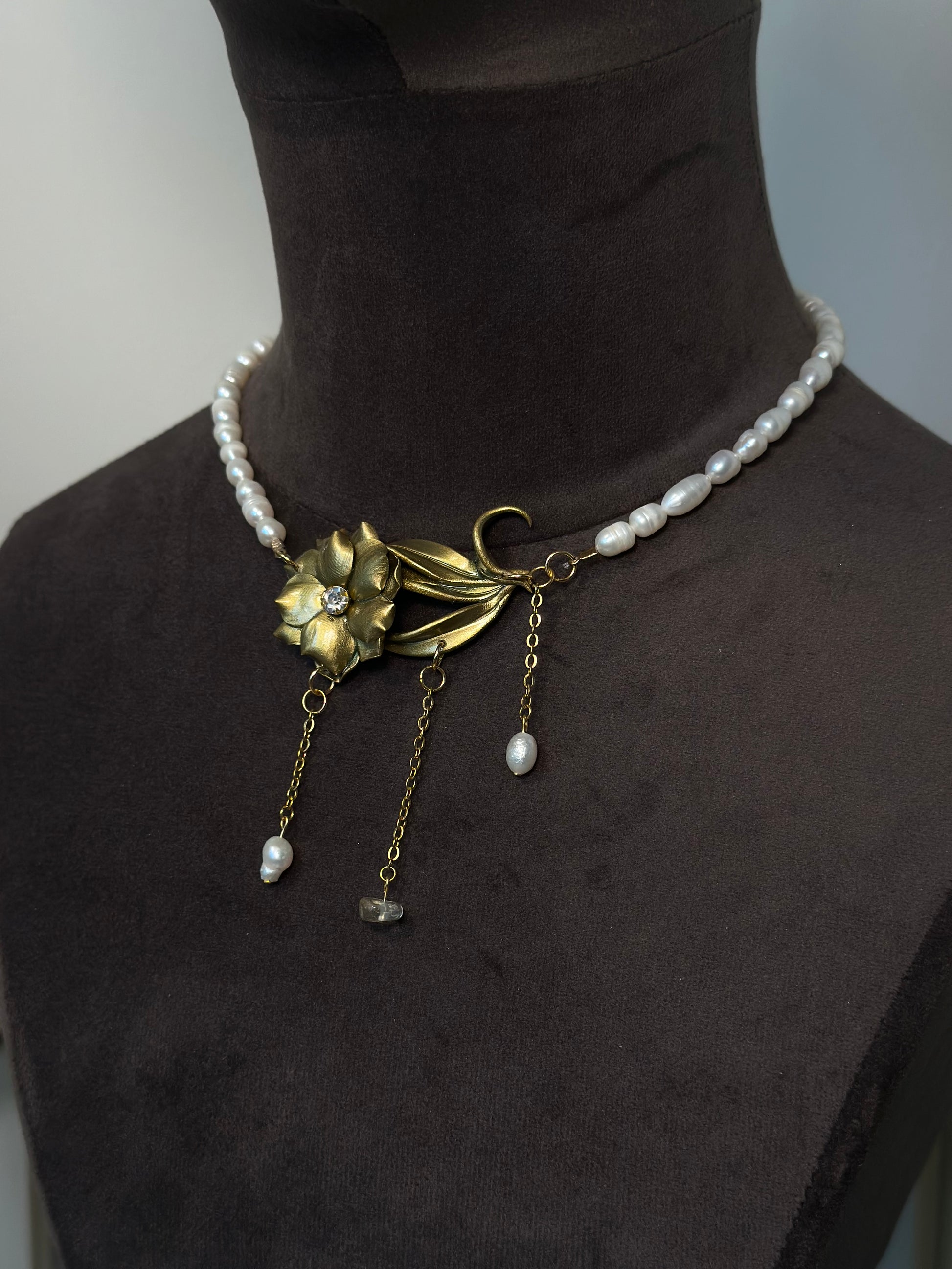 Sculptural floral necklace with gold tone flower and pearl accents, elegant handmade botanical jewelry for women