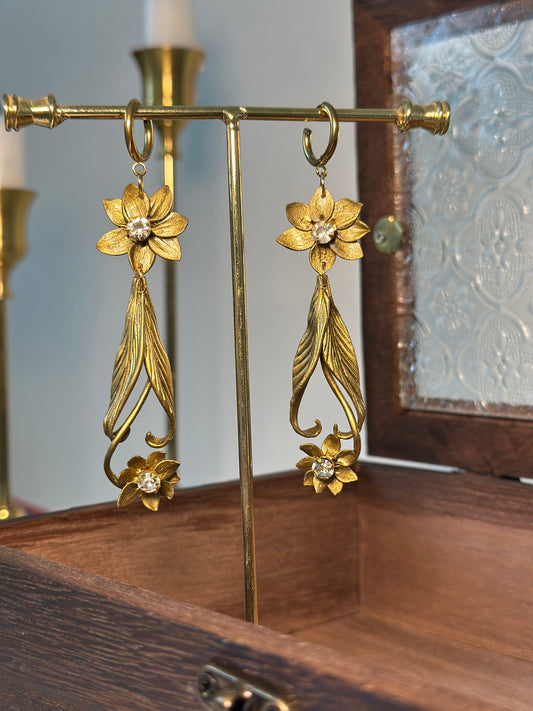 Handcrafted earrings in gold tones with delicate flowers and crystals, designed for elegant evening wear.
