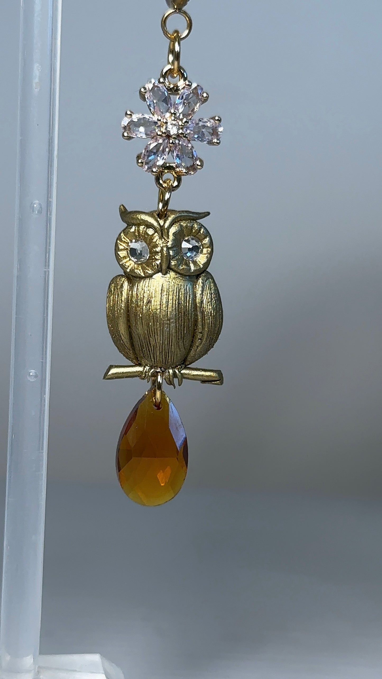 Elegant asymmetrical earrings with a sculpted maple leaf and golden owl, designed for those who find beauty in difference.