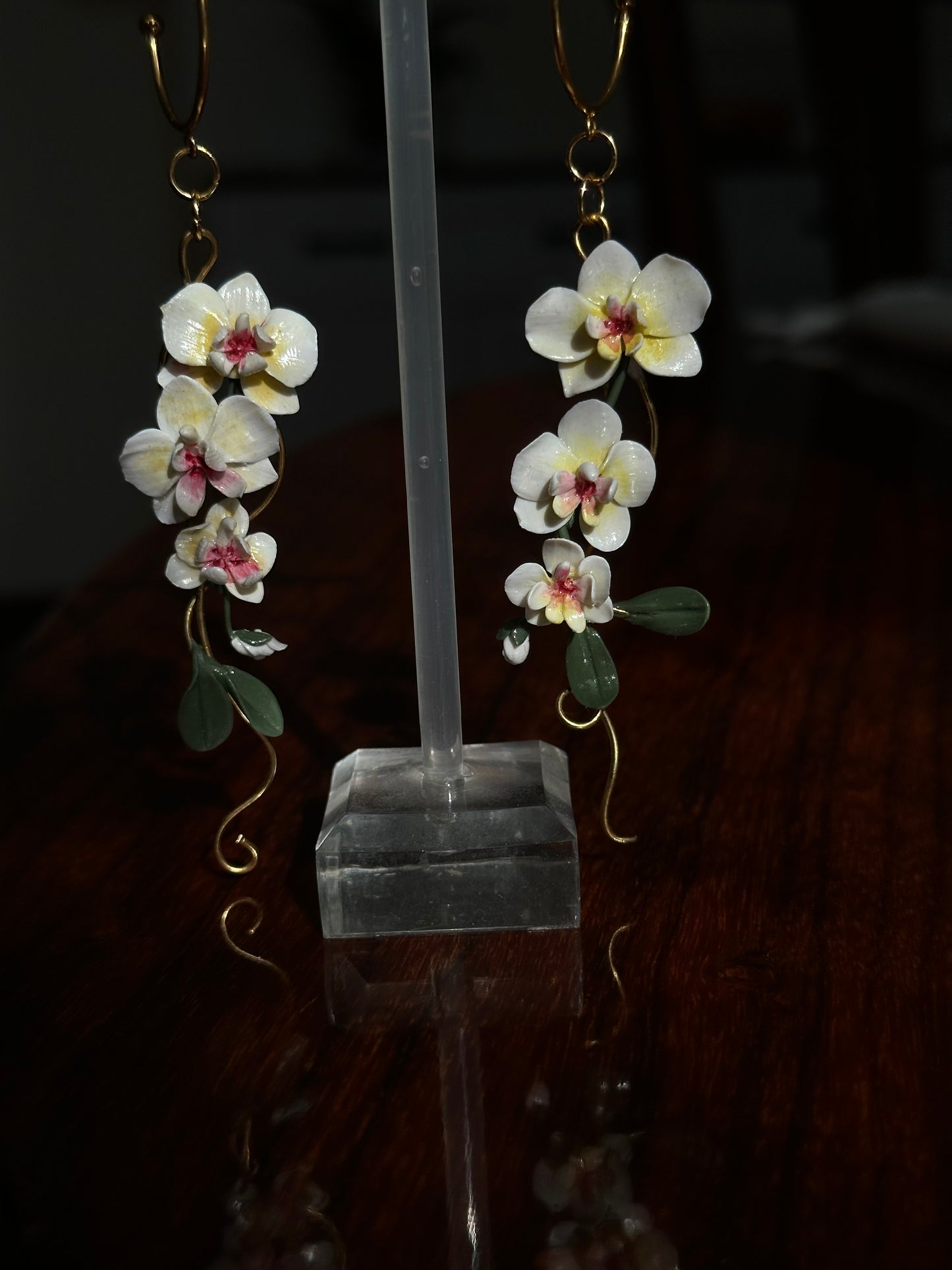Realistic orchid earrings handmade in Italy, with delicate ivory petals, soft yellow and pink details, and cascading floral movement.