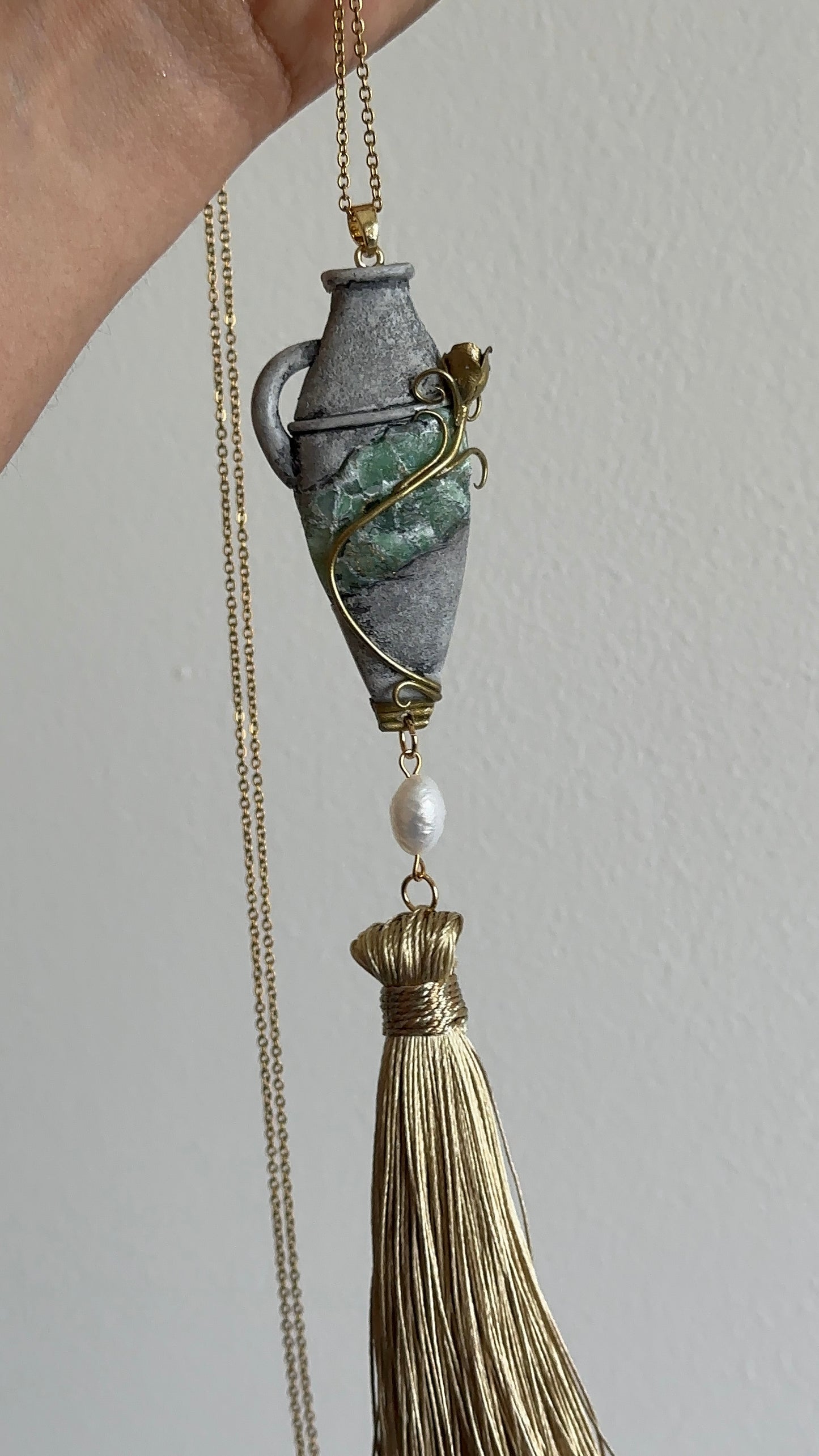     Sculptural vessel pendant necklace with thread tassel, green stone-inspired detail and pearl accent, unusual statement jewelry for elegant personal style.