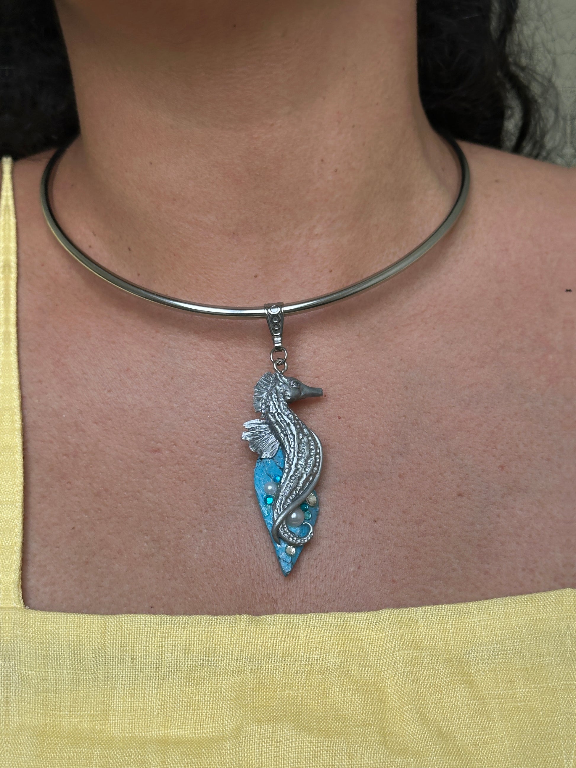     One of a kind silver seahorse pendant with faux turquoise details, worn as a bold artistic necklace for summer outfits