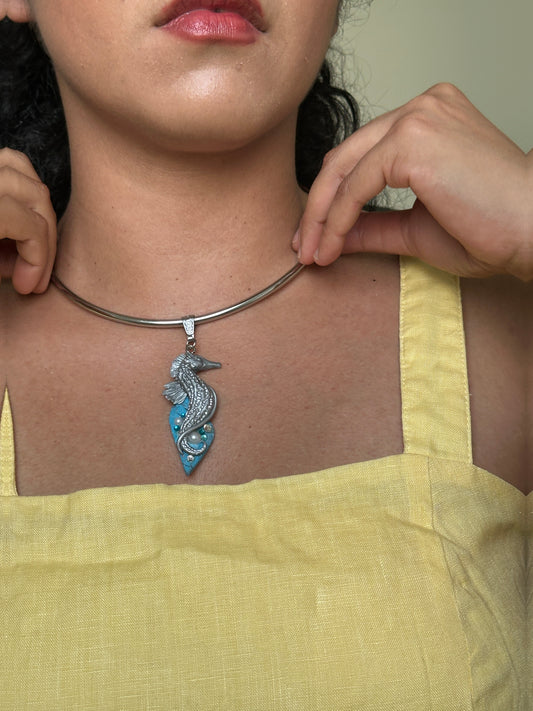     Silver seahorse pendant necklace with faux turquoise stone, styled with a yellow linen dress for an unusual summer statement look.