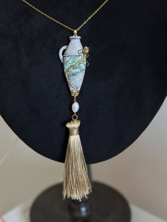     Handmade wearable relic tassel necklace with sculptural vessel pendant, green stone-like center and pearl accent for refined statement outfits.