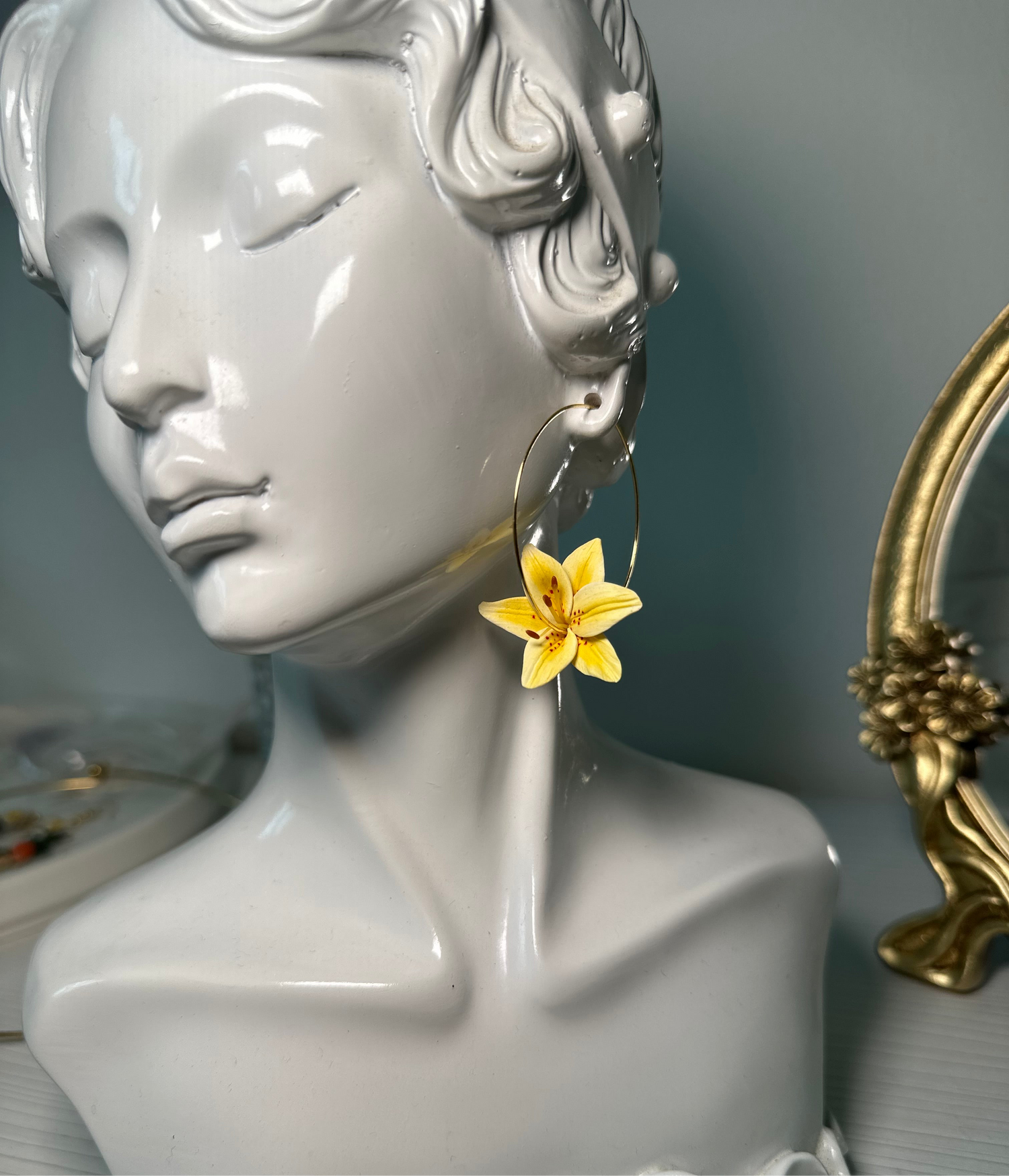 Close-up of handmade hoop earrings with white lilies – polymer clay flowers with stainless steel base, delicate and romantic design.