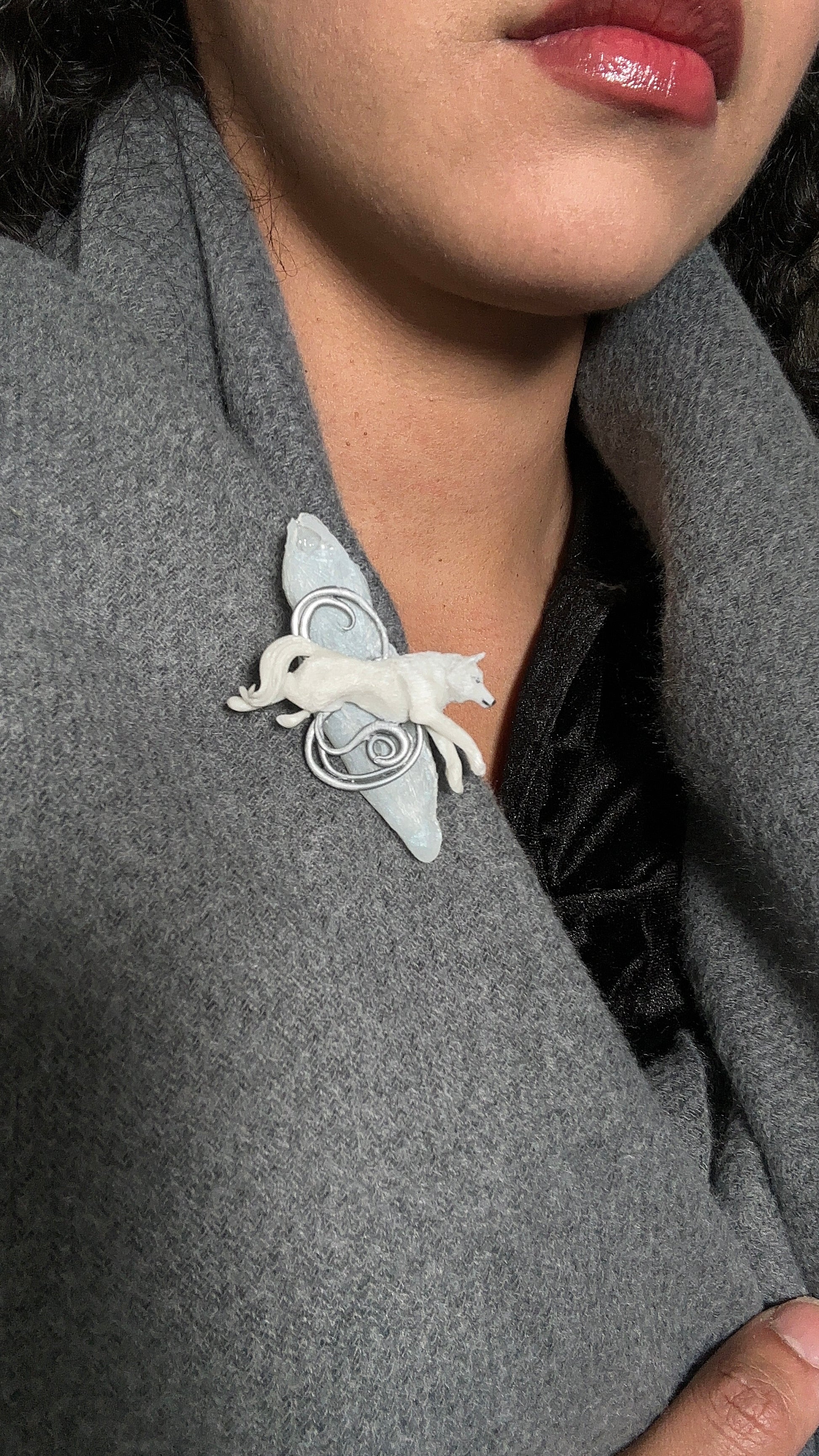 Minimalist Art Nouveau winter brooch with a white wolf and icy textures, crafted for upscale clients seeking refined wearable art.