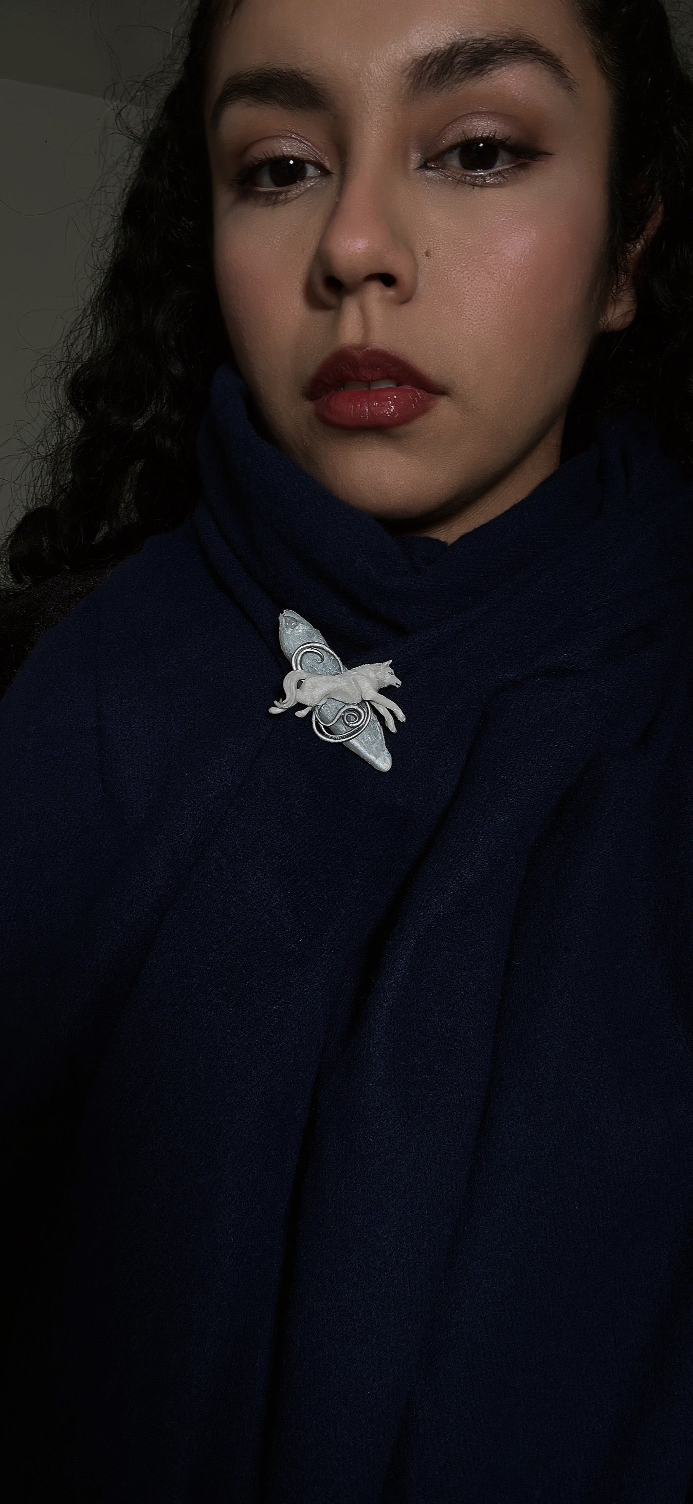 Designer wolf brooch in polymer clay and resin, photographed on a navy scarf — ideal for collectors of unique seasonal accessories.