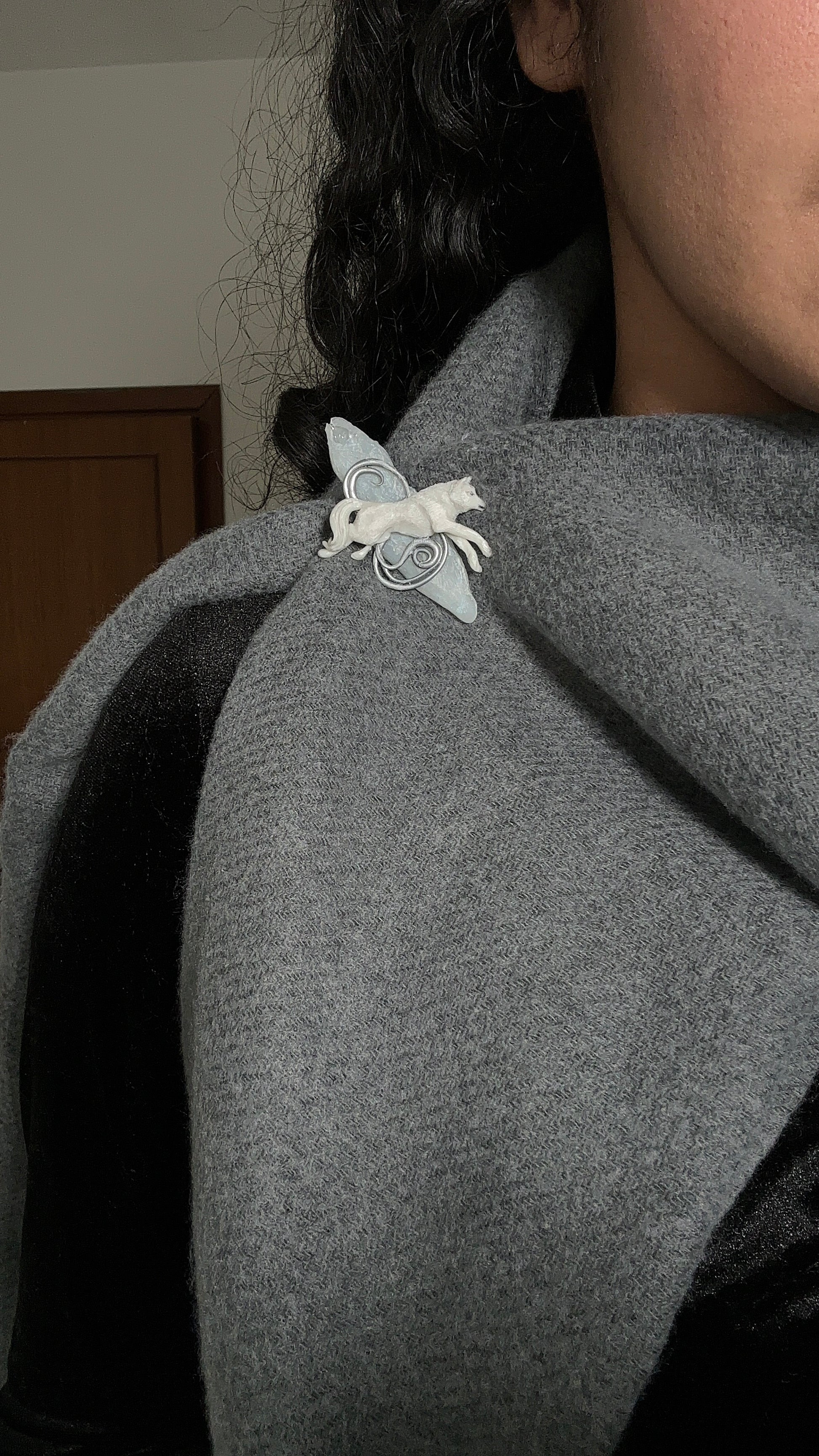 Elegant polymer clay and resin wolf brooch styled on a deep winter scarf — a refined accessory for fashion-forward buyers.