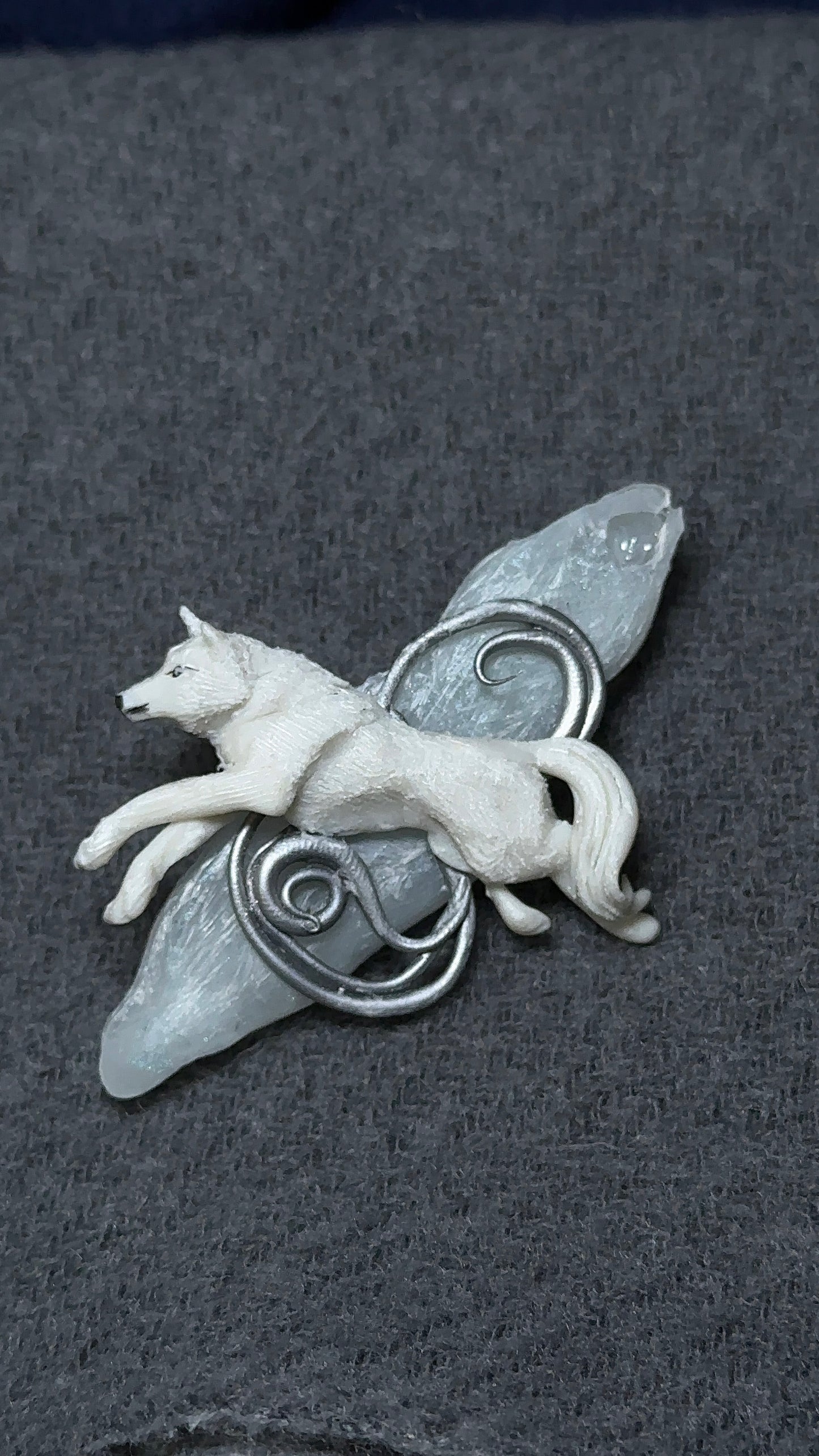 A luxury winter brooch featuring a hand-sculpted white wolf on an icy resin shard, designed for collectors of quiet, high-end accessories.