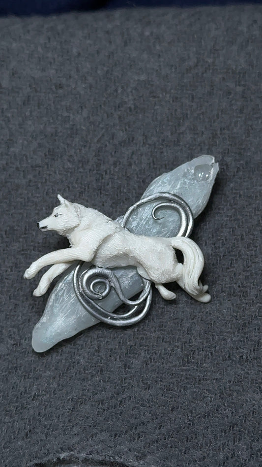 A luxury winter brooch featuring a hand-sculpted white wolf on an icy resin shard, designed for collectors of quiet, high-end accessories.