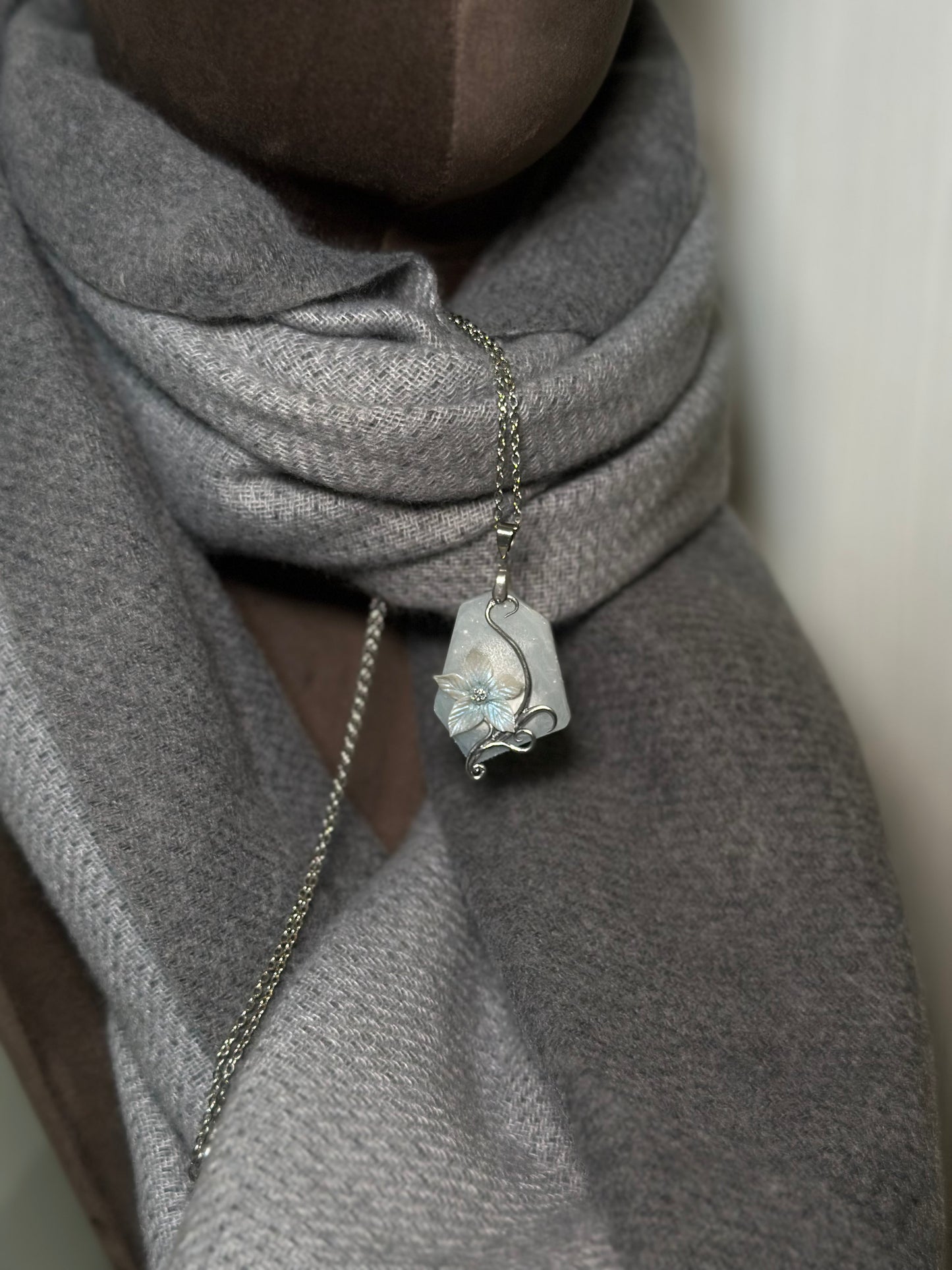 Close up of sculpted ice flower pendant with frosted resin base, artistic necklace for fashion collectors and GRWM styling