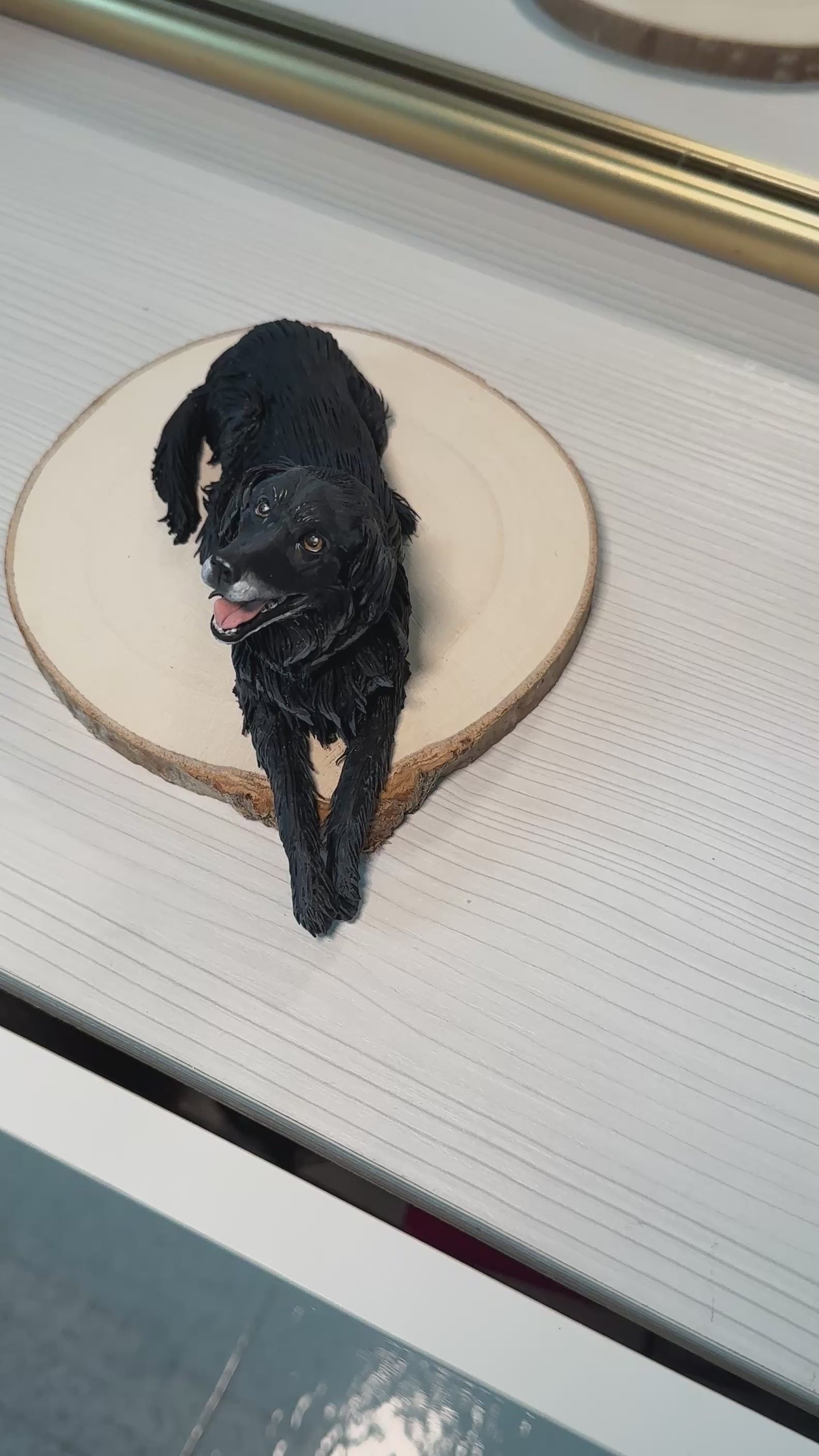 Slow close-up video showing a handcrafted dog memorial statue on a wooden base with name plaque. The camera moves around to highlight the lifelike details and textures of Dodò’s face and fur.